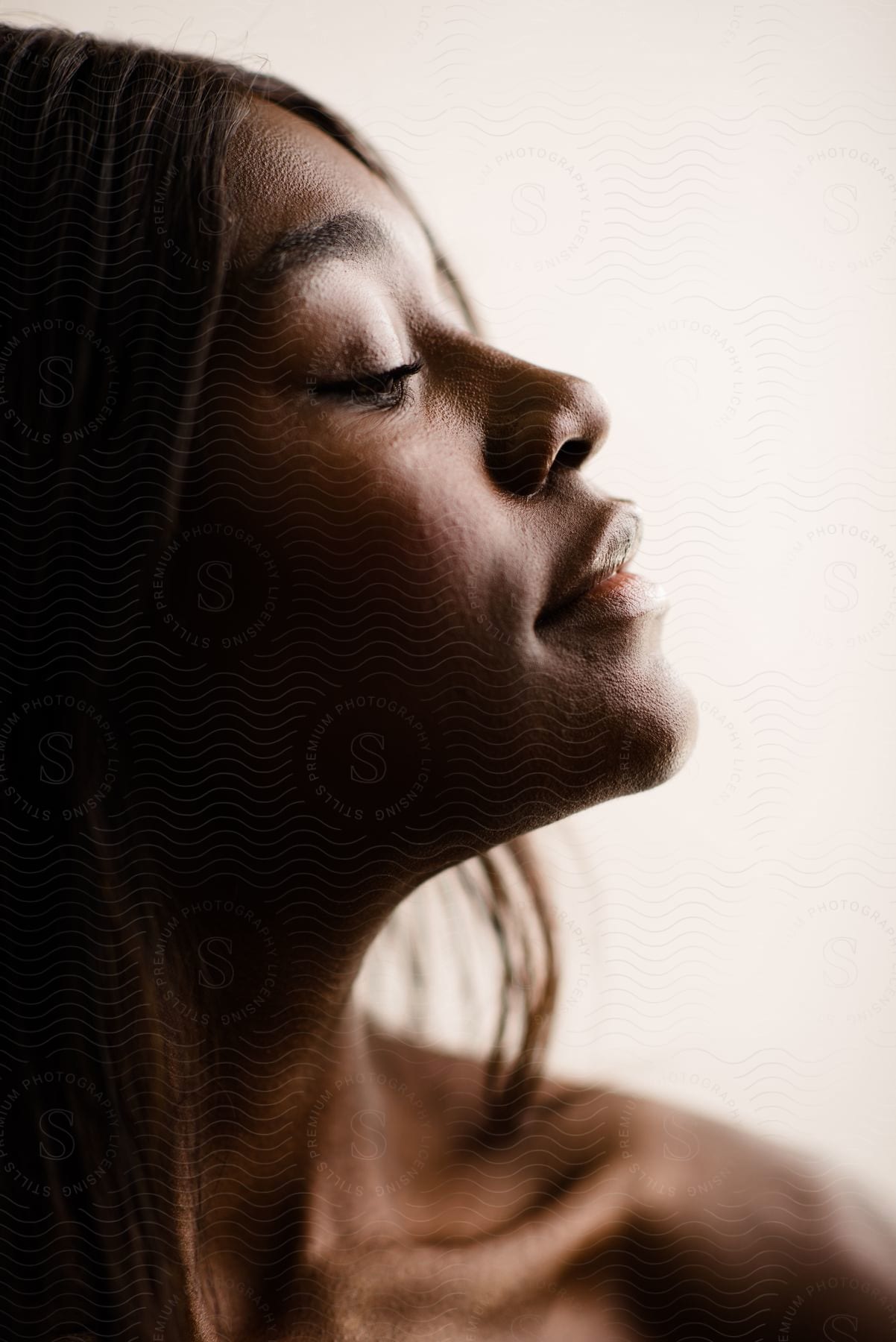 A side profile portrait of a woman with natural sunlight on her face.