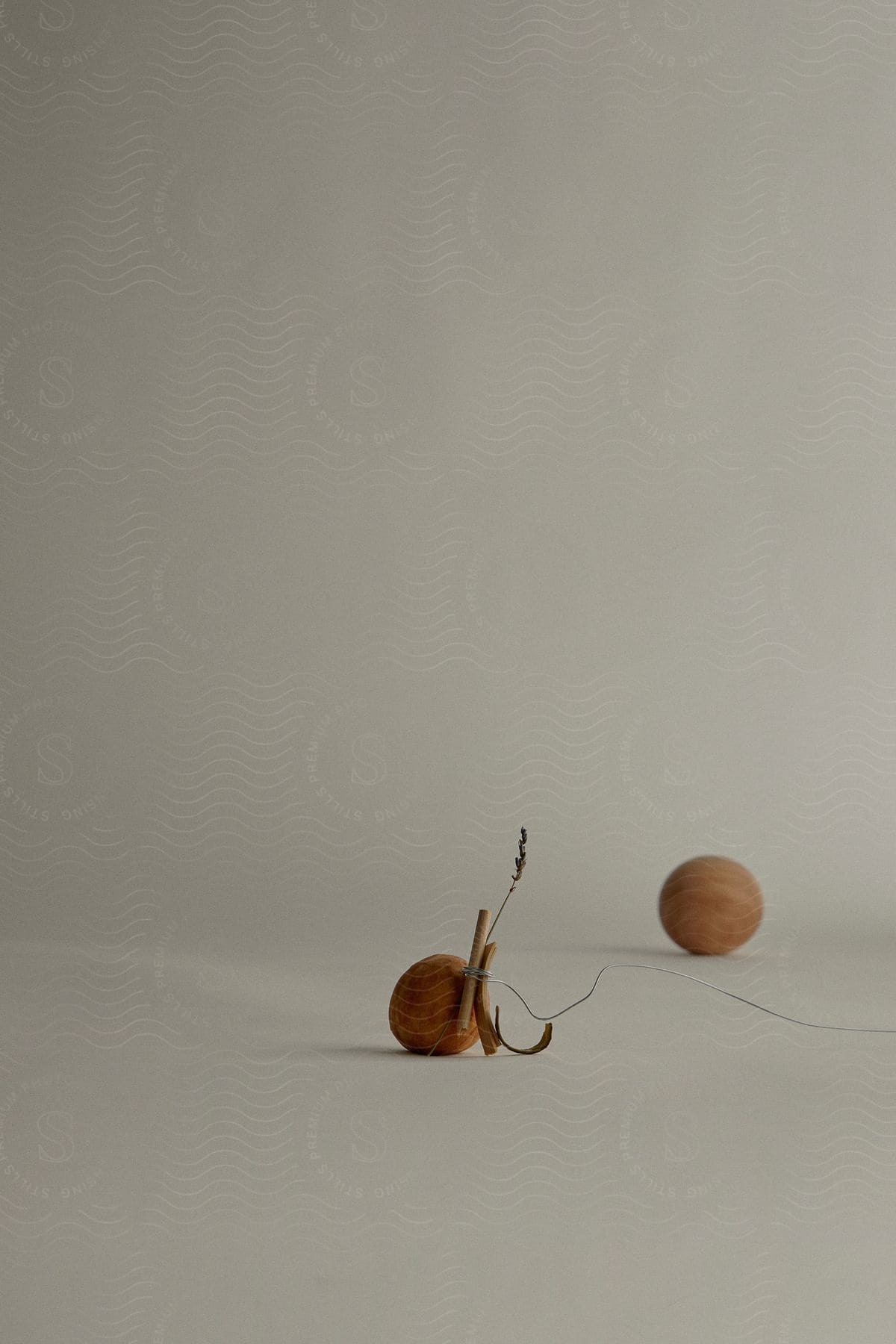 Two wooden tops, one upright with a string wrapped around it and the other blurred in the background, on a neutral surface.