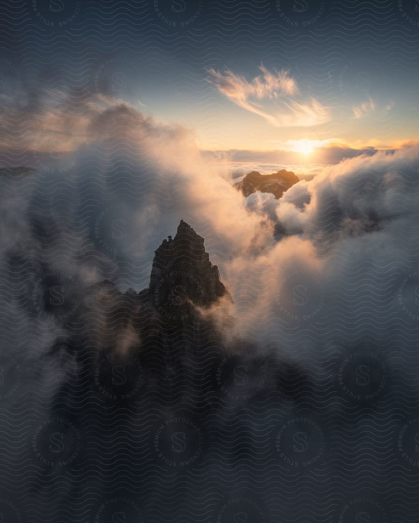 A majestic mountain emerges through a sea of clouds under a golden dawn.