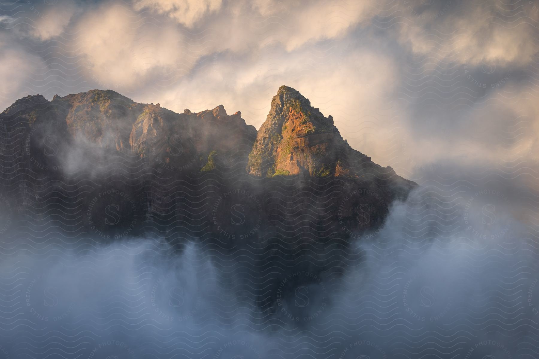 Landscape Of Majestic Mountains That Rise Above The Clouds, Bathed In Sunlight