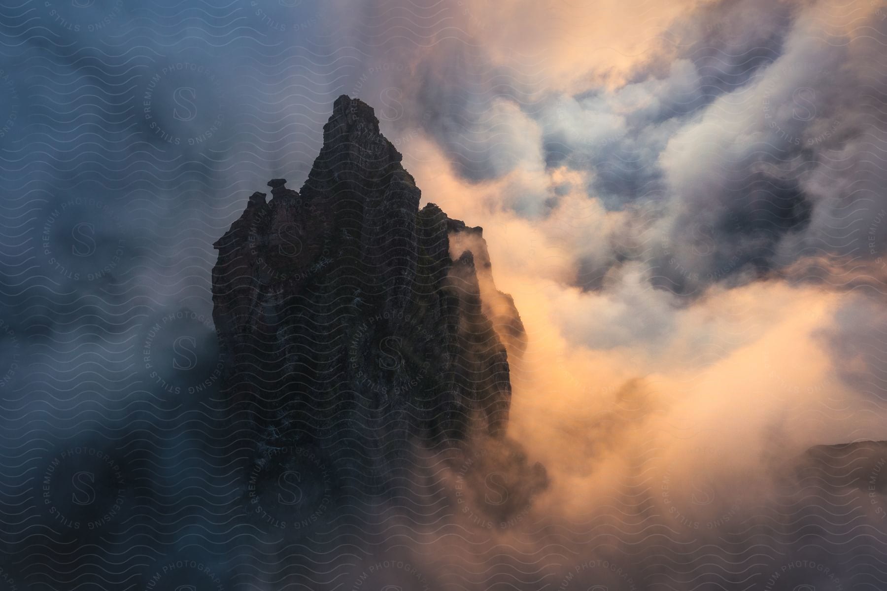 A majestic mountain emerges from the clouds, illuminated by a soft, mysterious light.