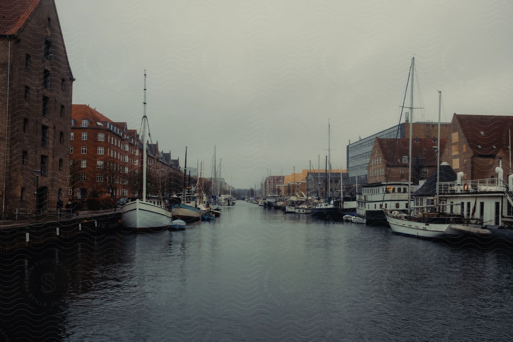 A lot of boats parked in a river in the middle of a city.