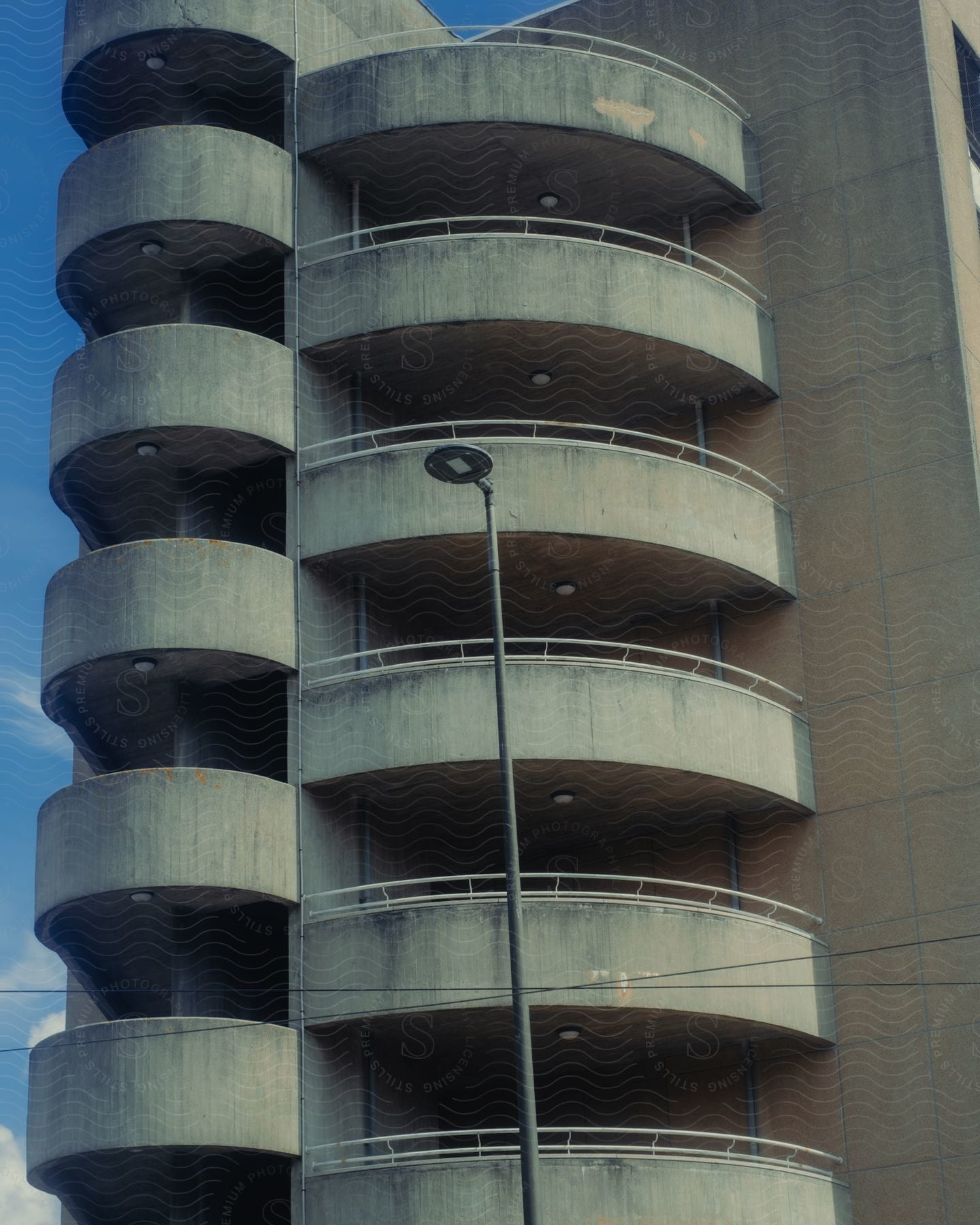 Exterior architecture of a modern building with grayish patterned balconies.