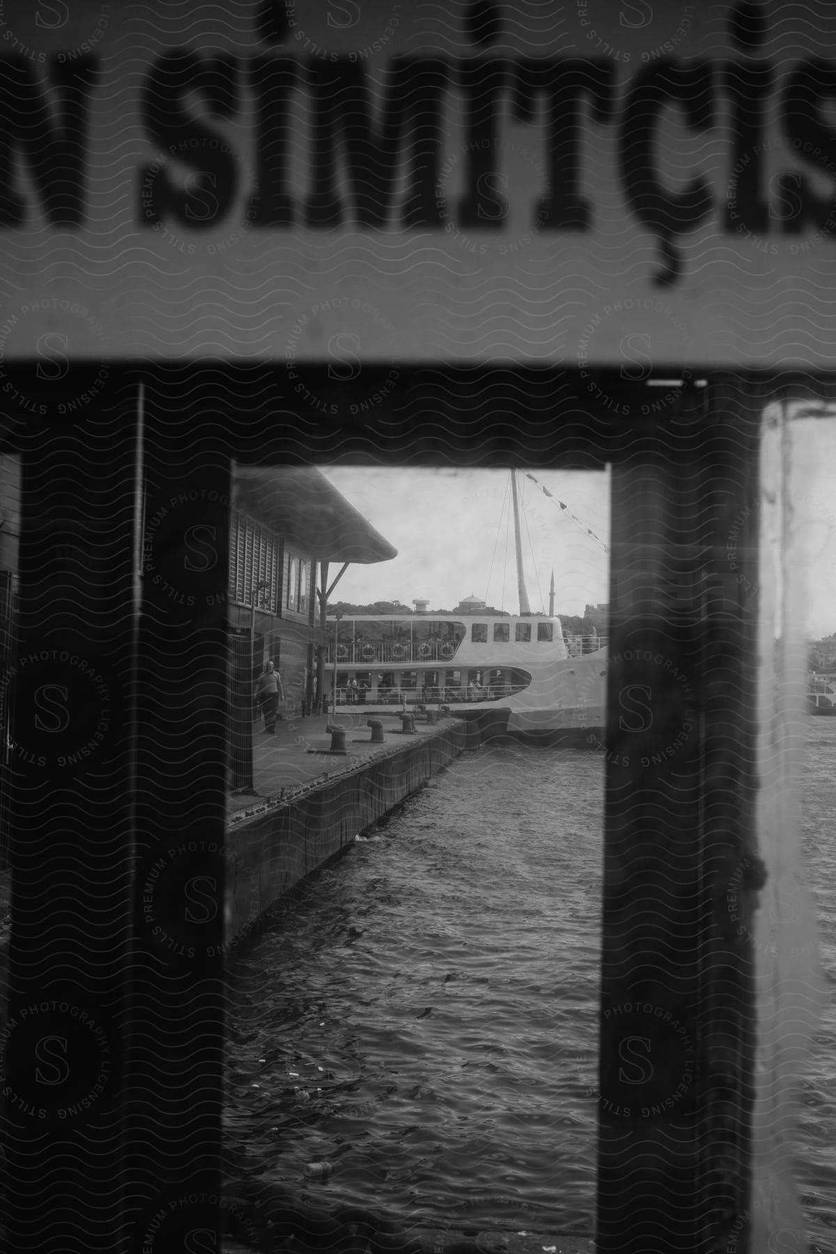 The view through a window where you can see the sea, a pier and a boat