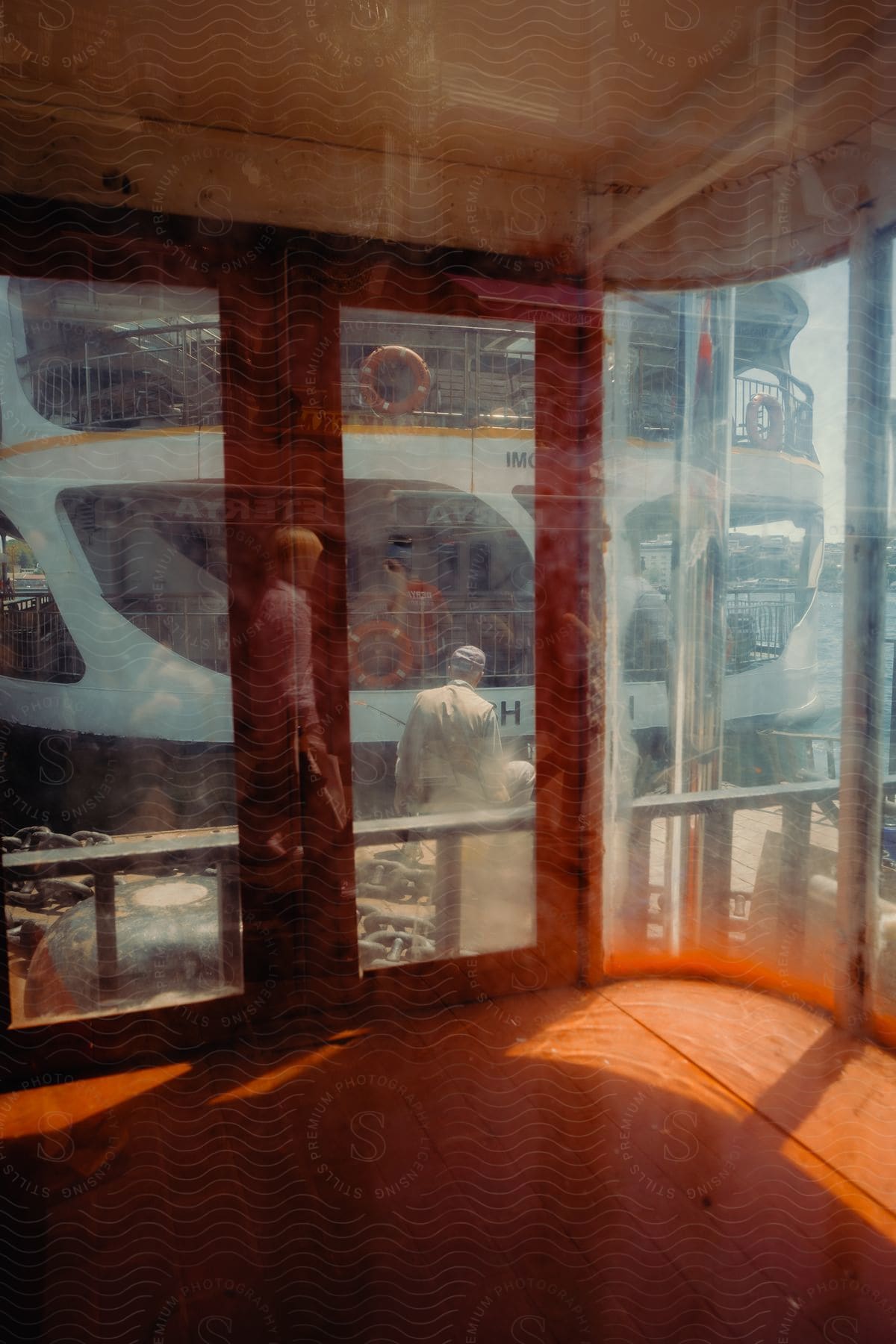 View from inside a mirrored window cabin overlooking a tourist boat.