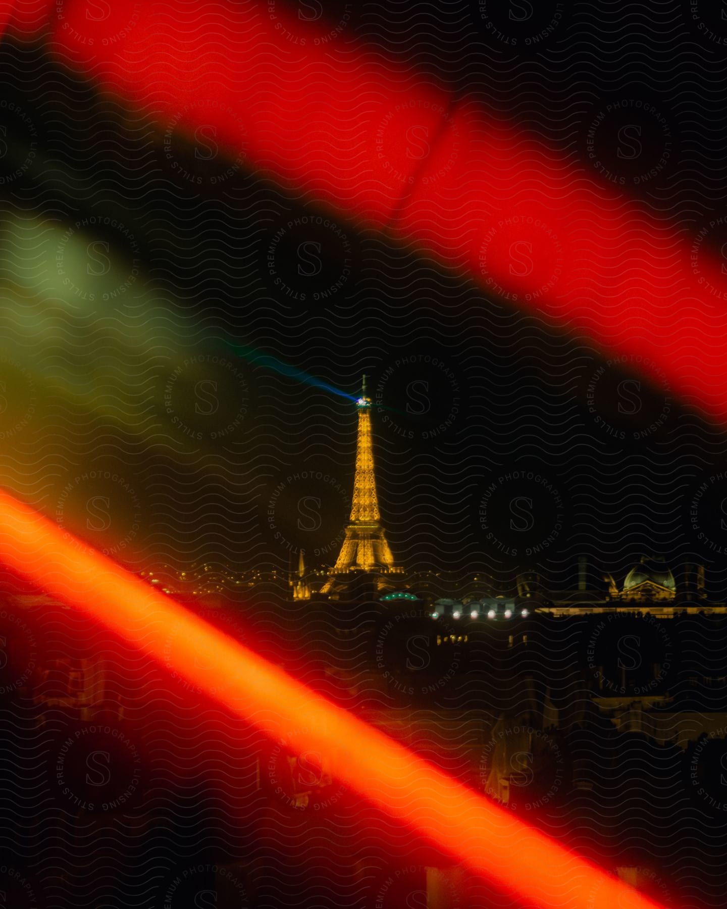 The Eiffel Tower illuminated at night, viewed through an abstract overlay of red light.