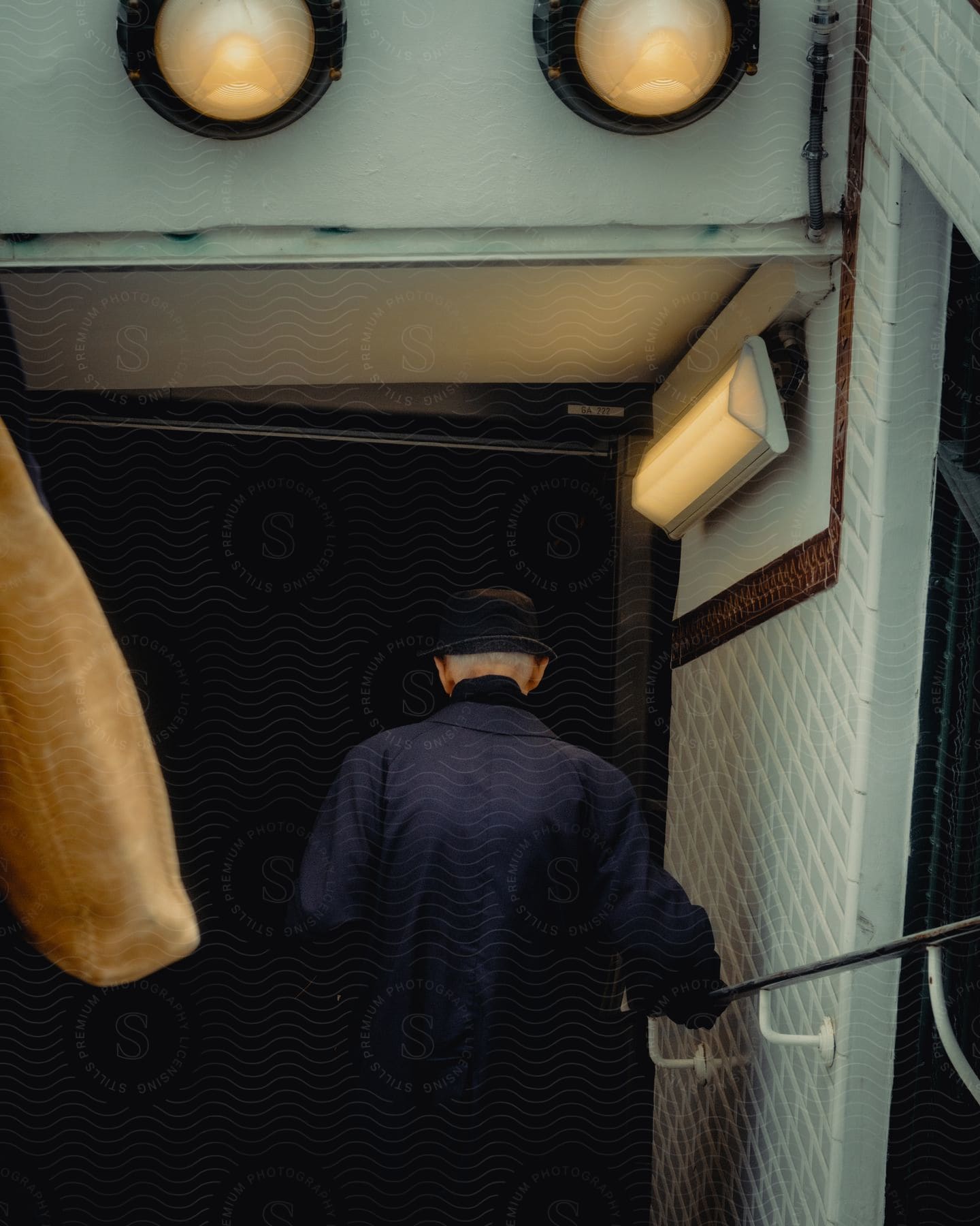 A Man Holds The Railing As He Walks Into A Building