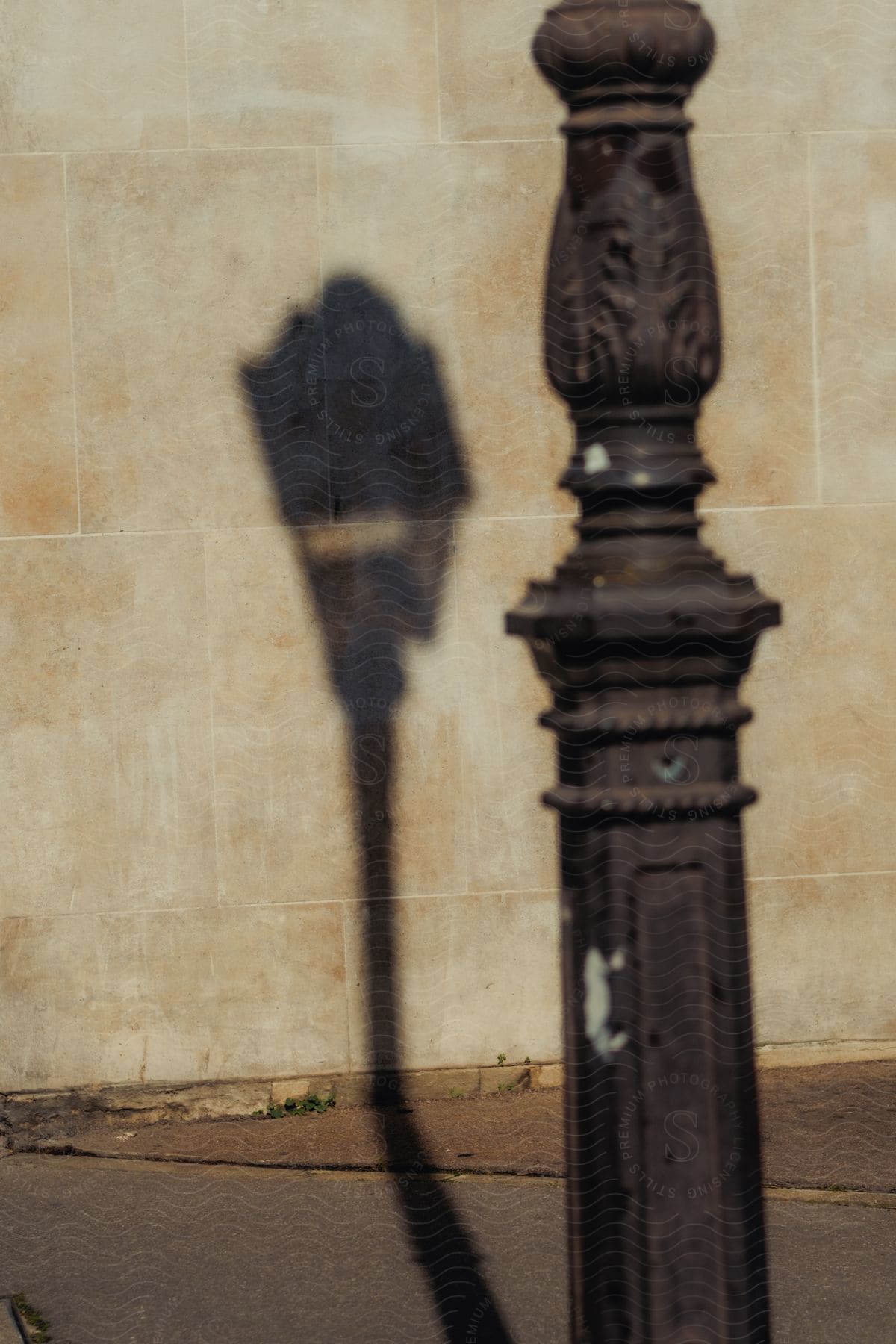 An old street lamp's shadow falling on a building's wall.