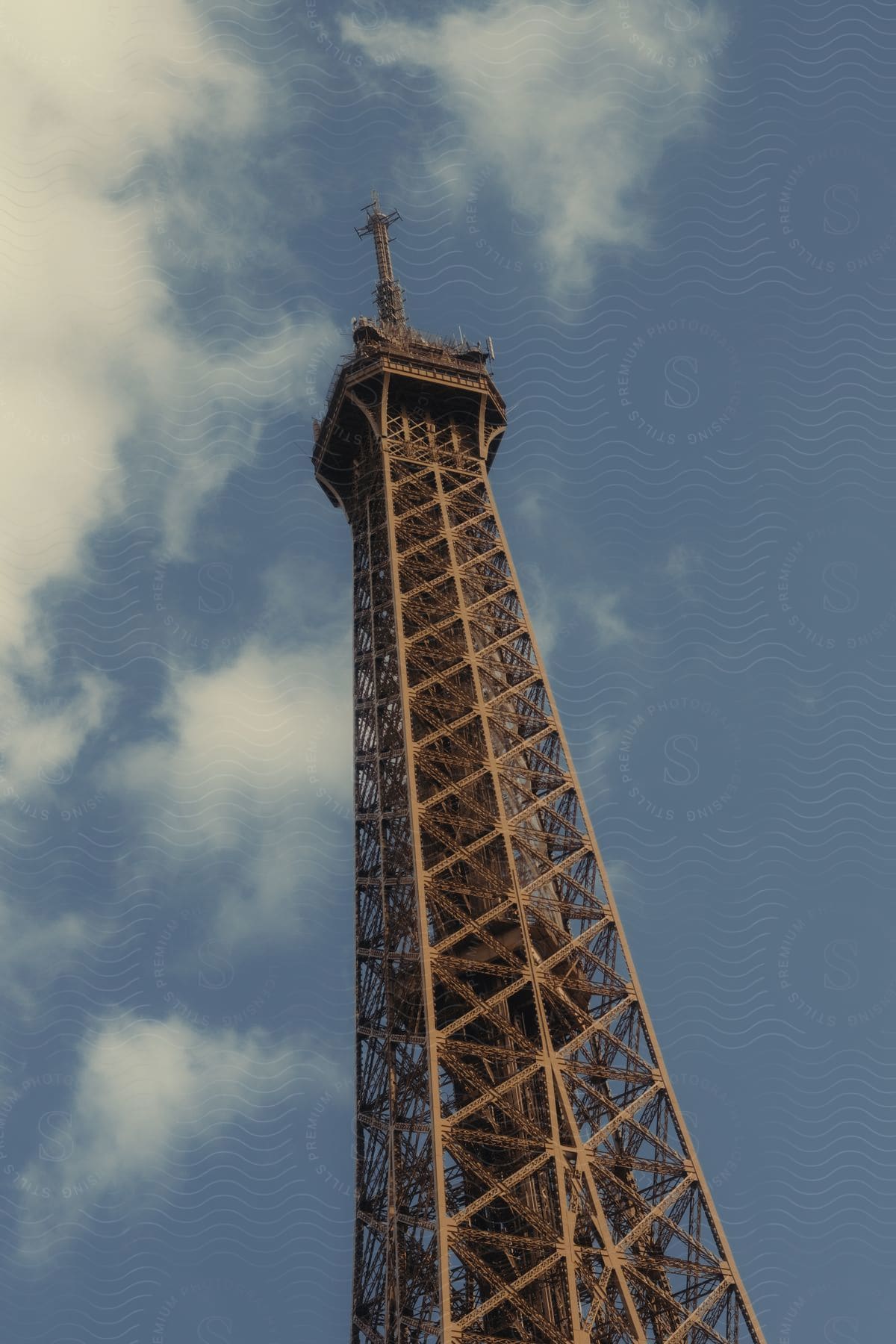 The upper third of the Eiffel Tower on a sunny day.