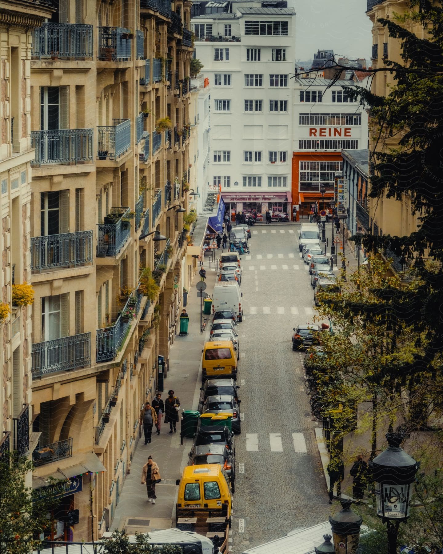 Cars line the street next to an apartment building in an urban area.