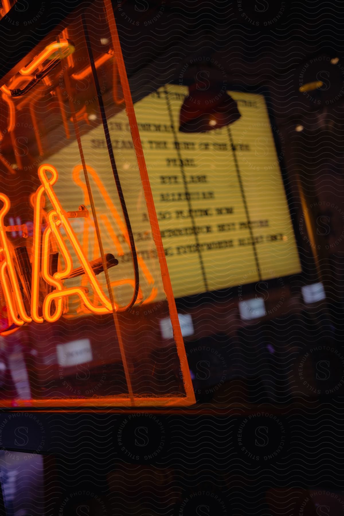 Red neon sign in the window of a restaurant and, in the background, a menu.