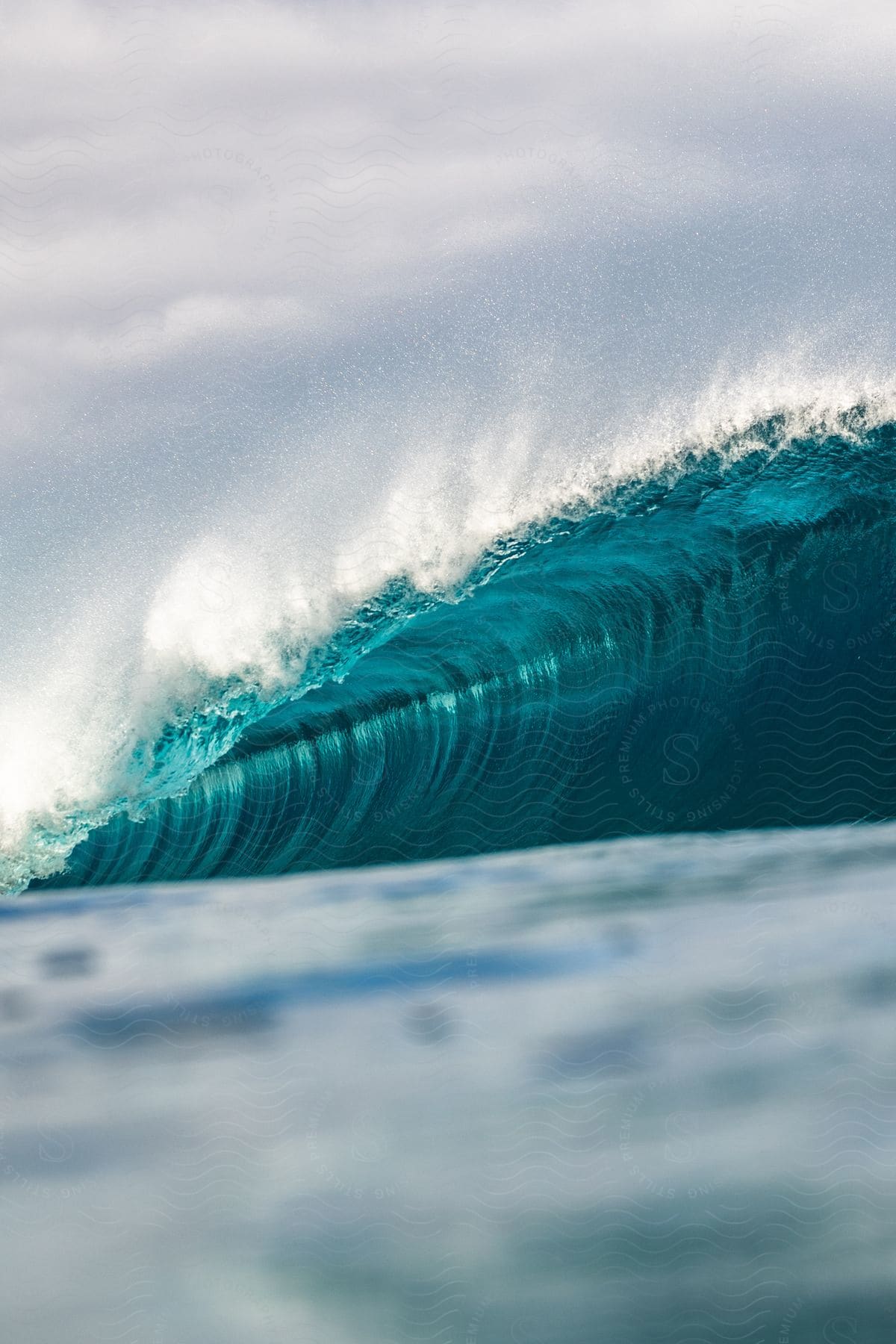 A blue Ocean wave moves across the surface of the water