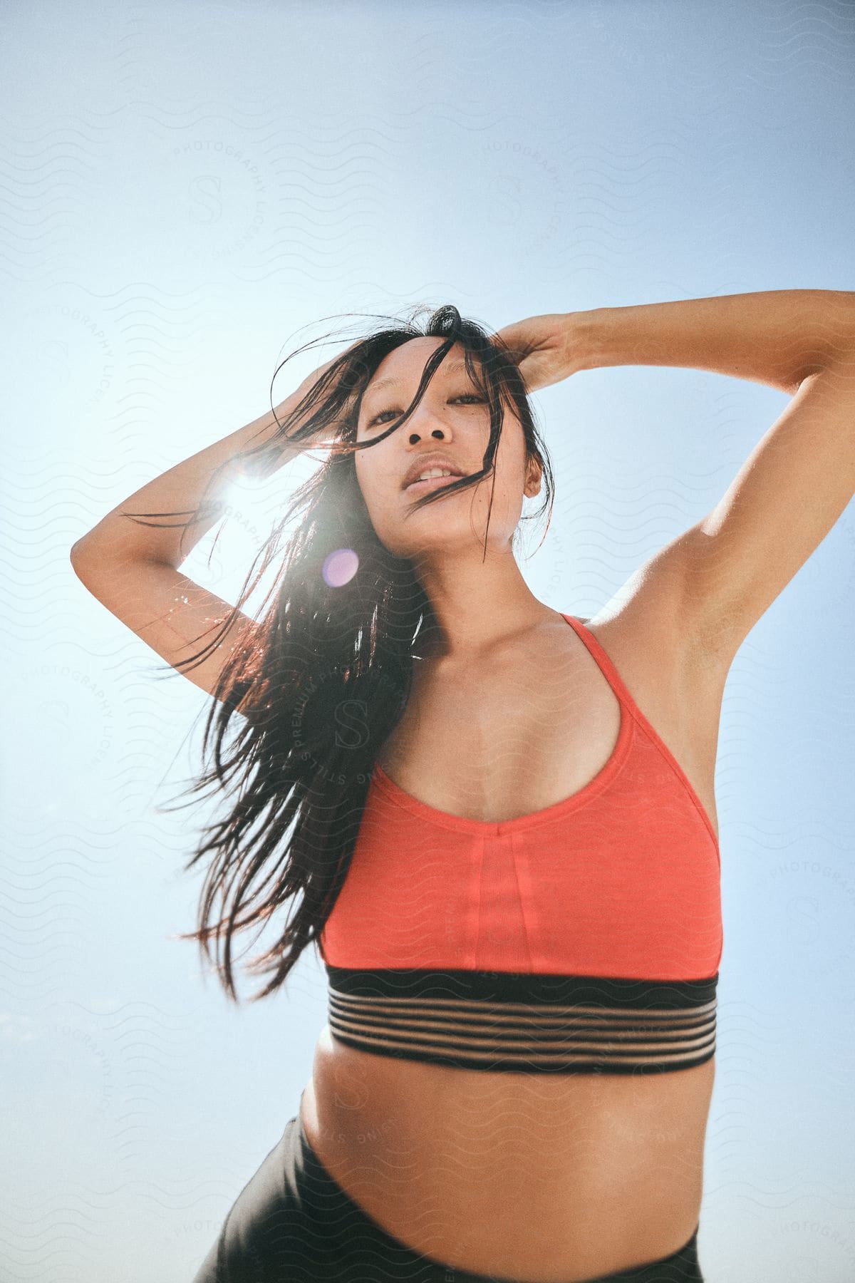 An Asian woman modeling a red sports bra.