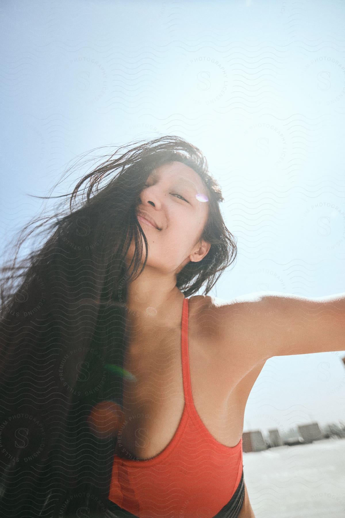 An Asian woman modeling a red sports bra.