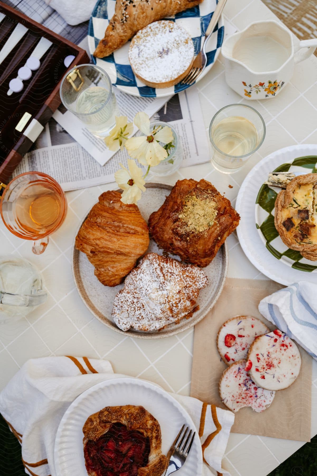 Backgammon game lies on table strewn with pastries.