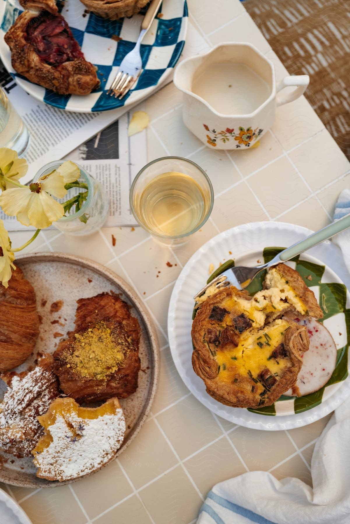 A table set for a meal with plates of pastries, bowls, and cutlery.