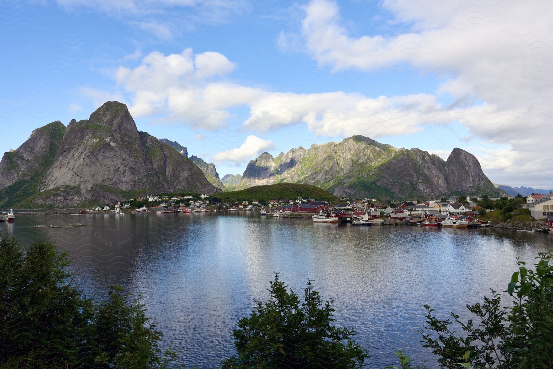 A coastal town on the Lofoten archipelago at the base of mountains under a blue sky