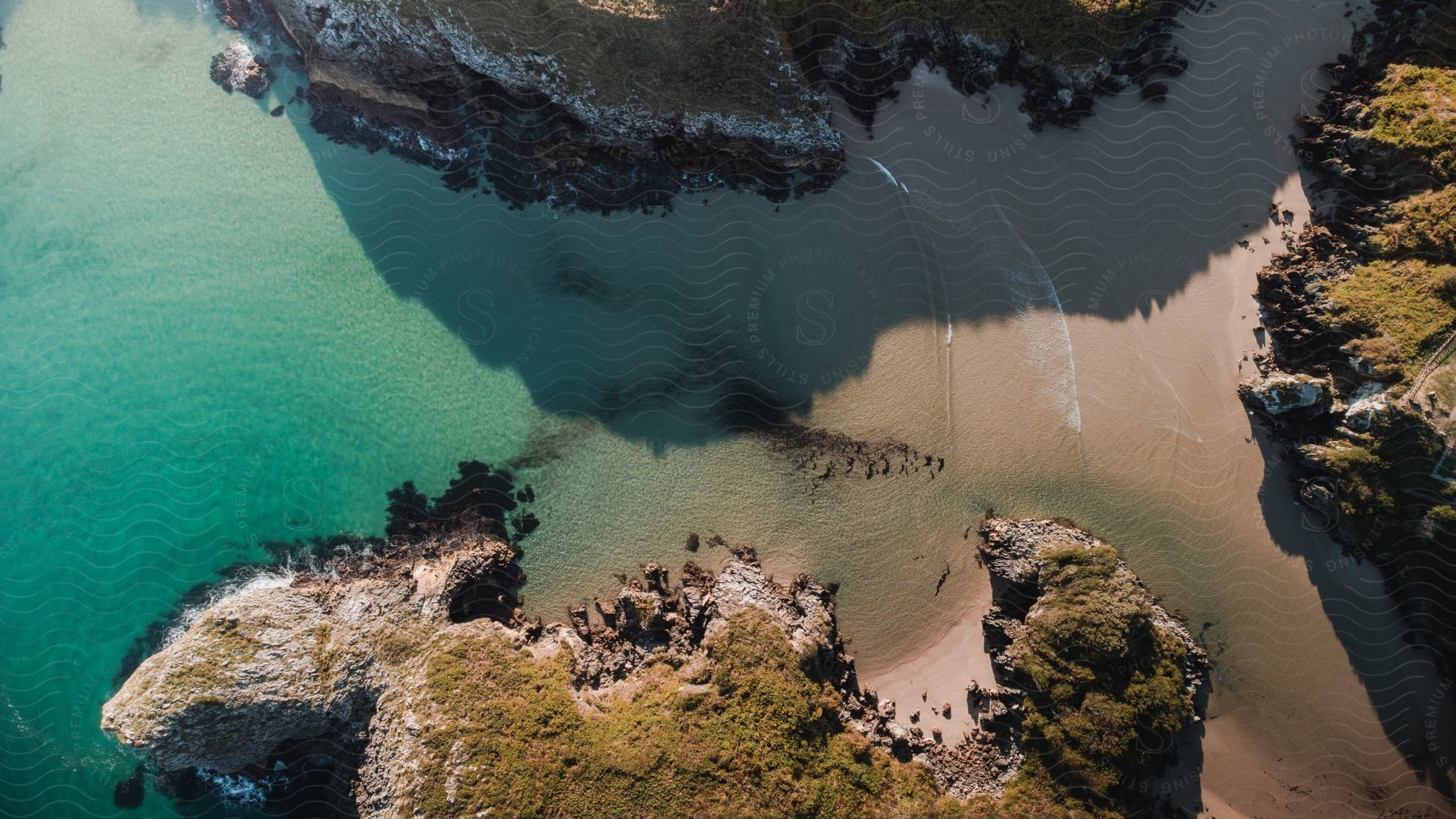 Cliffs surrounding an inlet beach with azure water.