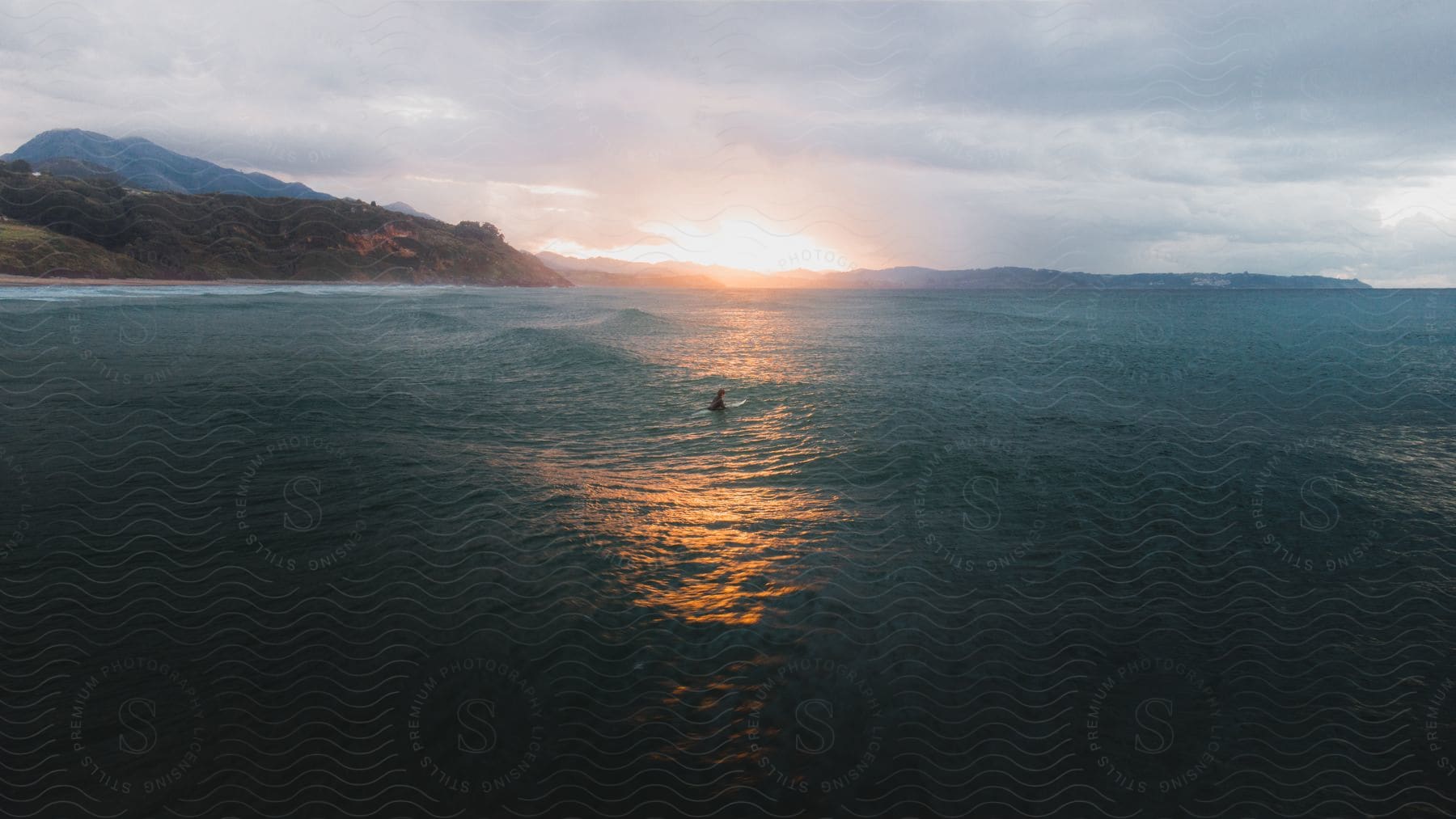 A surfer paddles out into the ocean.