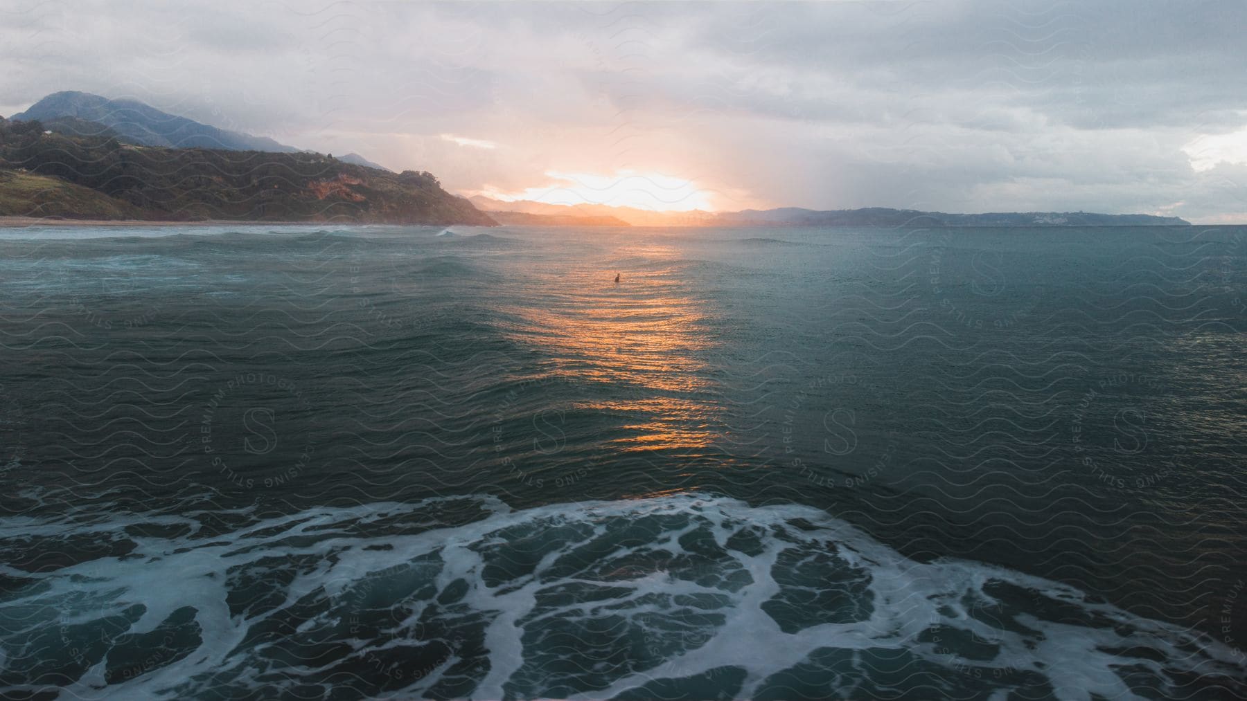 Aerial Of A Coastline Near A Body Of Water At Sunset