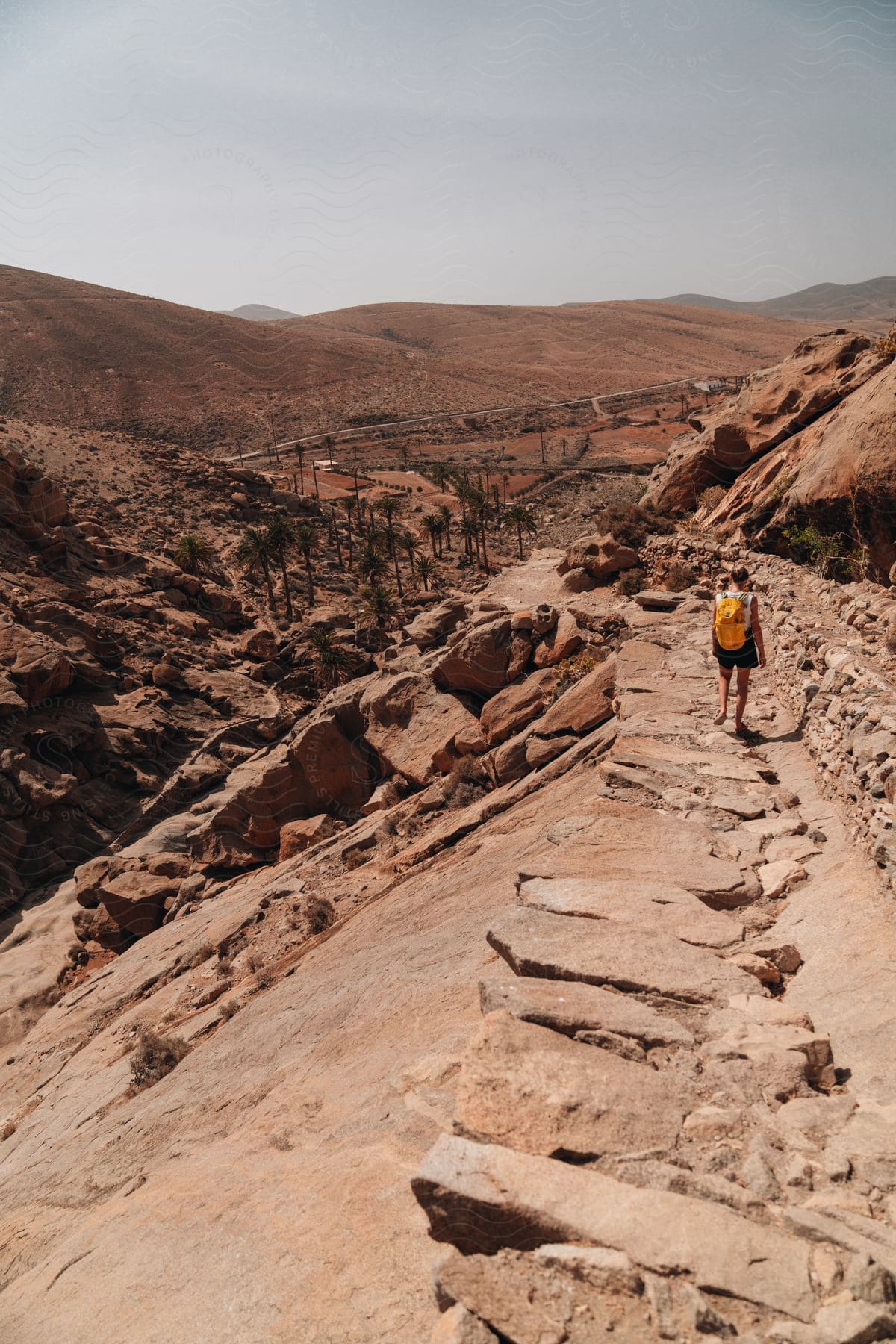 A backpacker walking near an archeological dig in the desert.