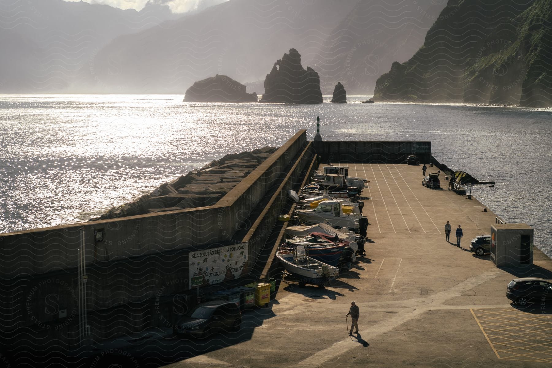 Panorama of a pier by the sea with parked boats and yachts and in the background a landscape of an island with mountains around it