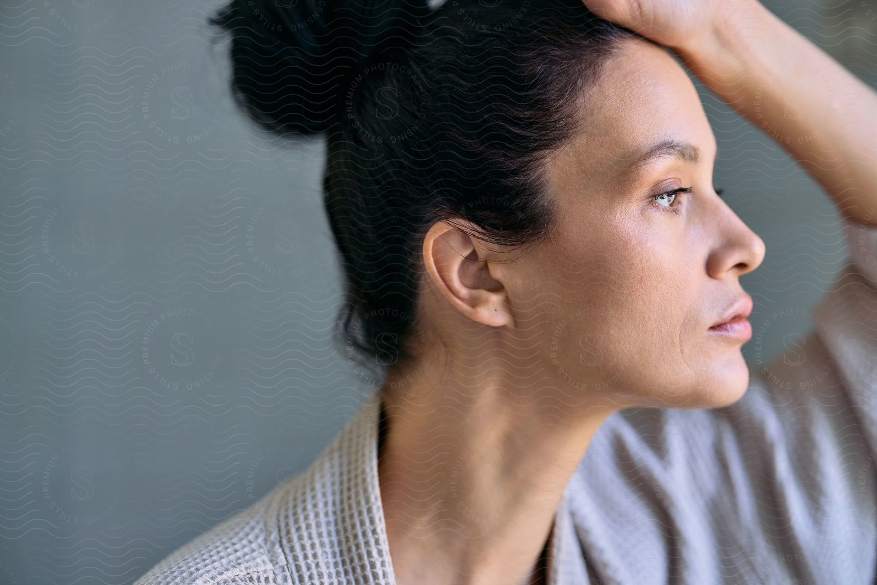 A Woman Resting Her Hand On Her Head While Looking Away