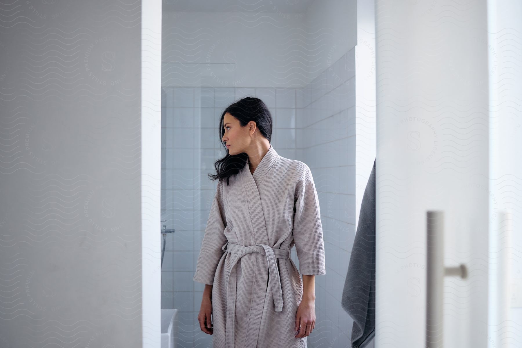 Model wearing gray bathrobe while inside bathroom