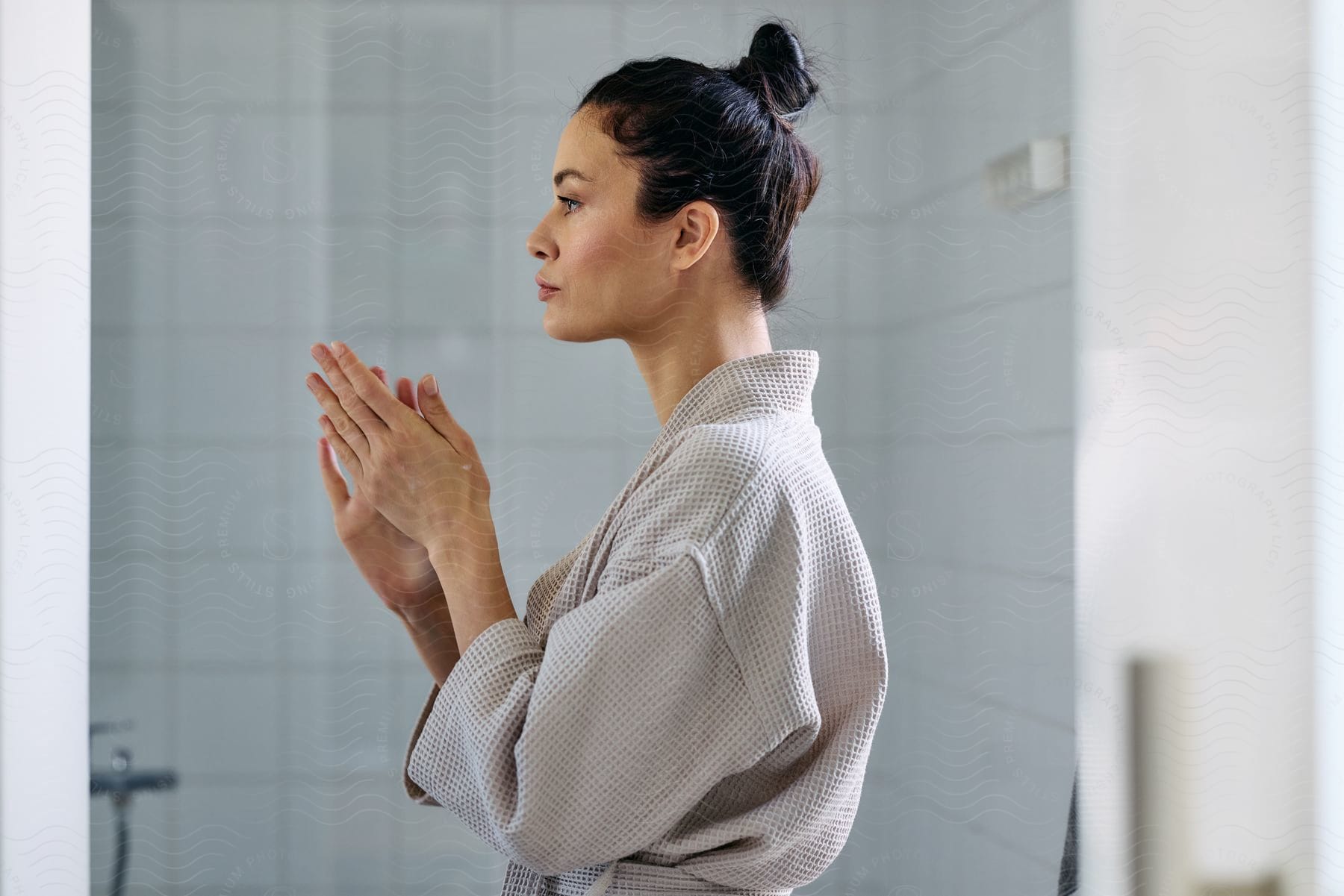 A woman wearing a robe in a bathroom