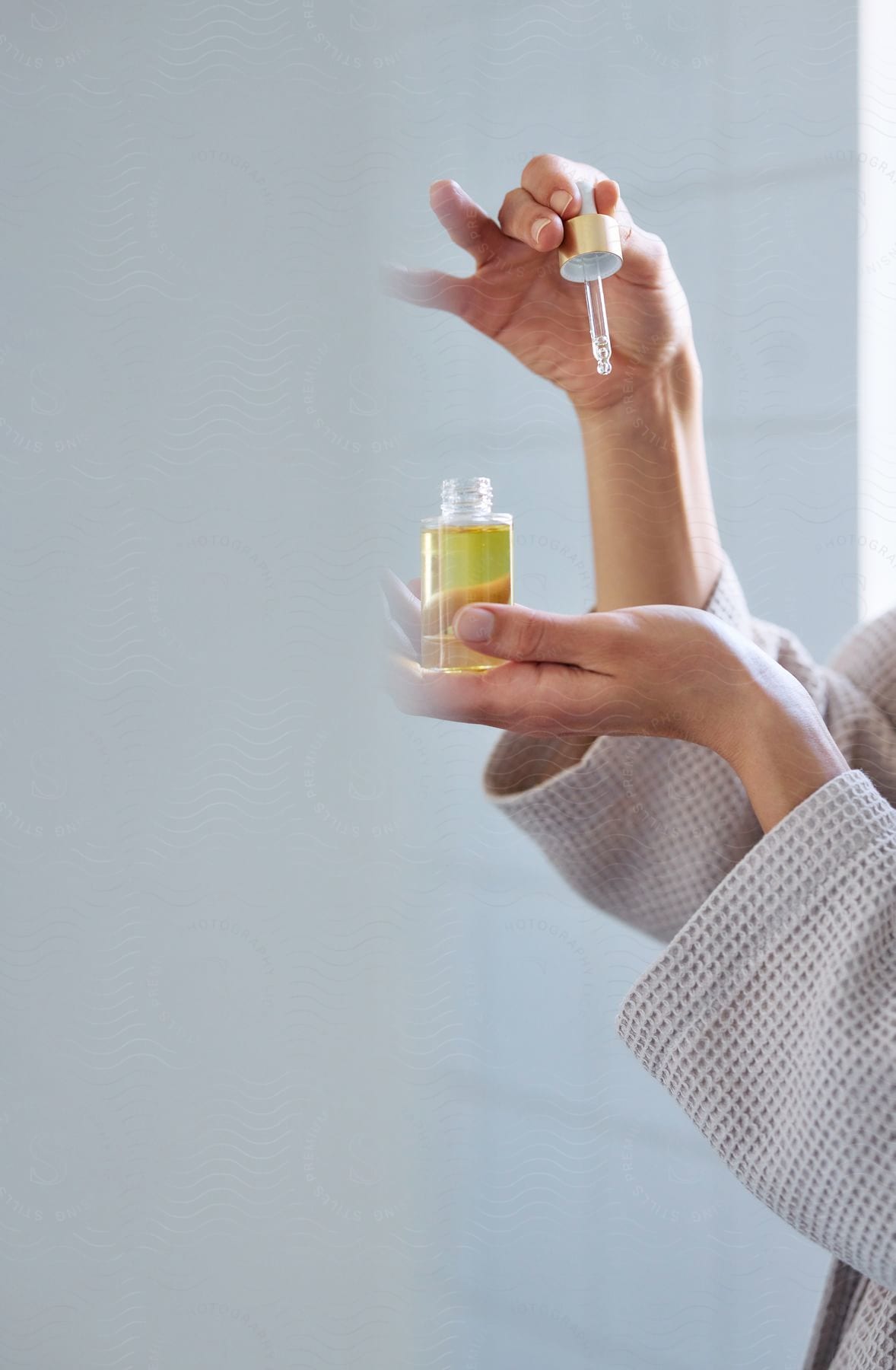 A close up of a woman putting oil on her skin.