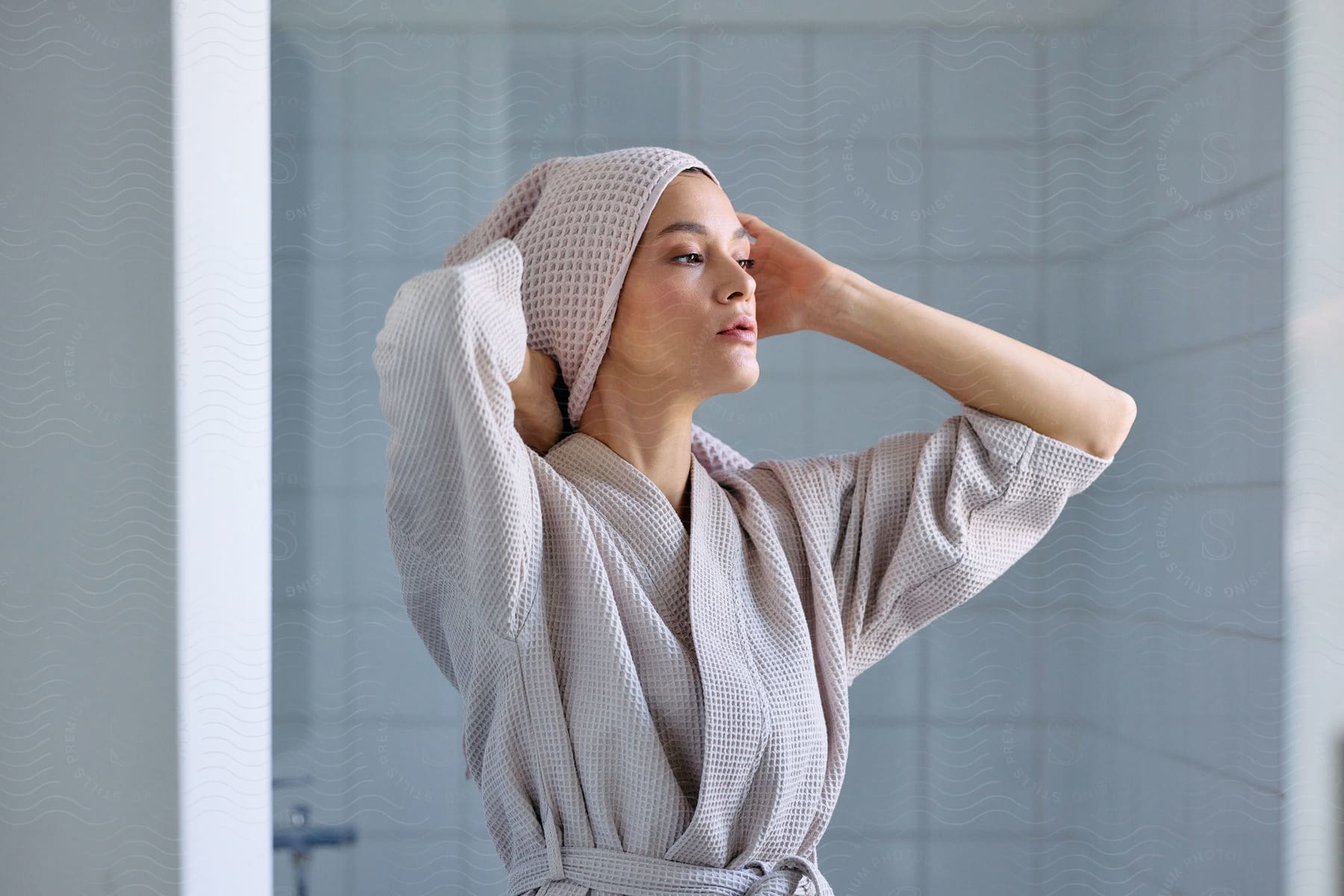 A woman in a bathrobe toweling her hair.