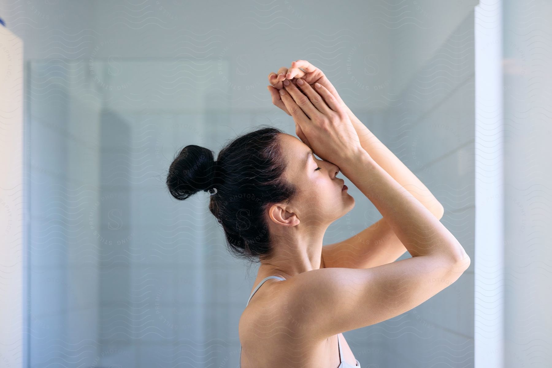 A young lady rests her arm on her face, closing her eyes.