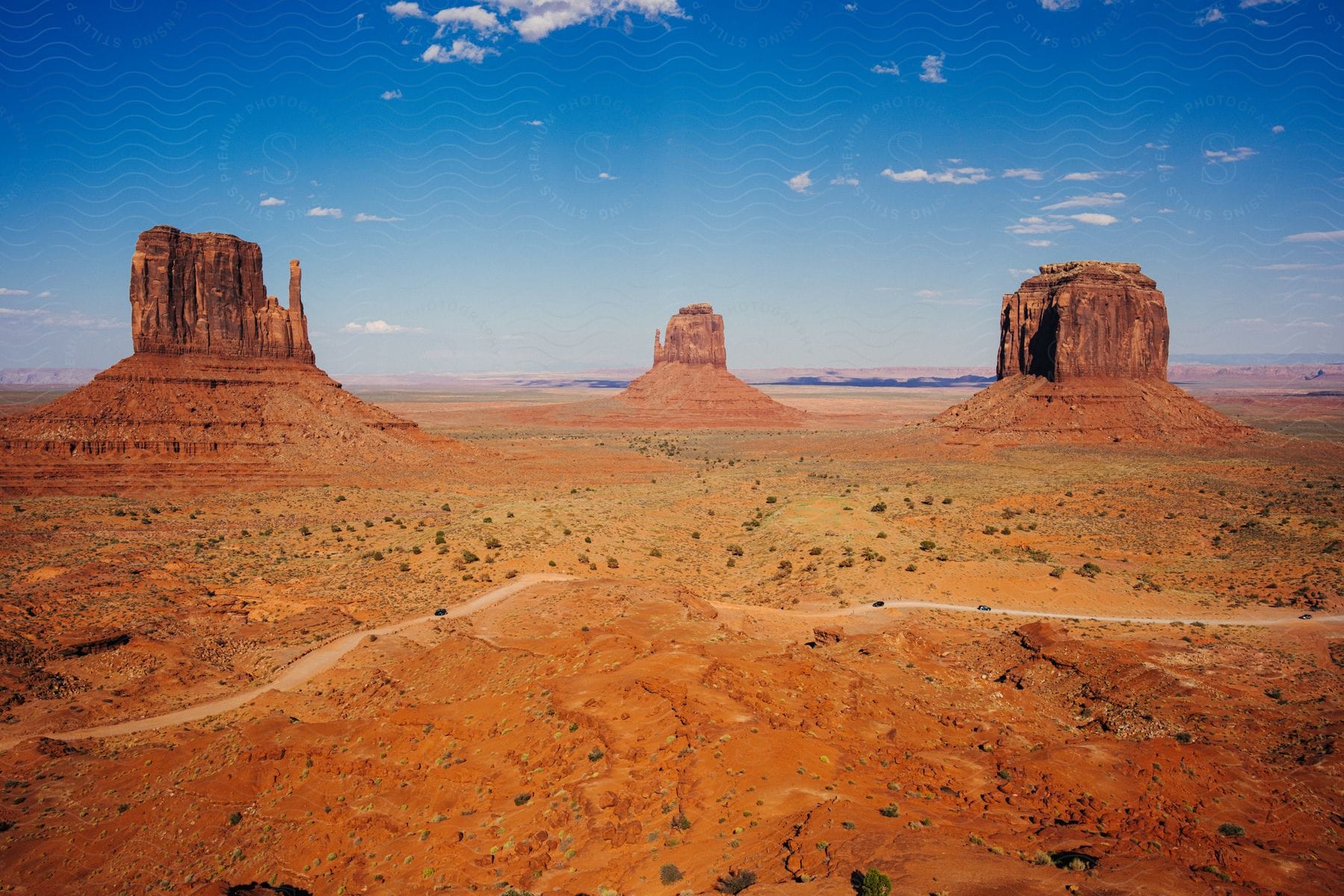 three mesas existing in the distance with a road in the foreground