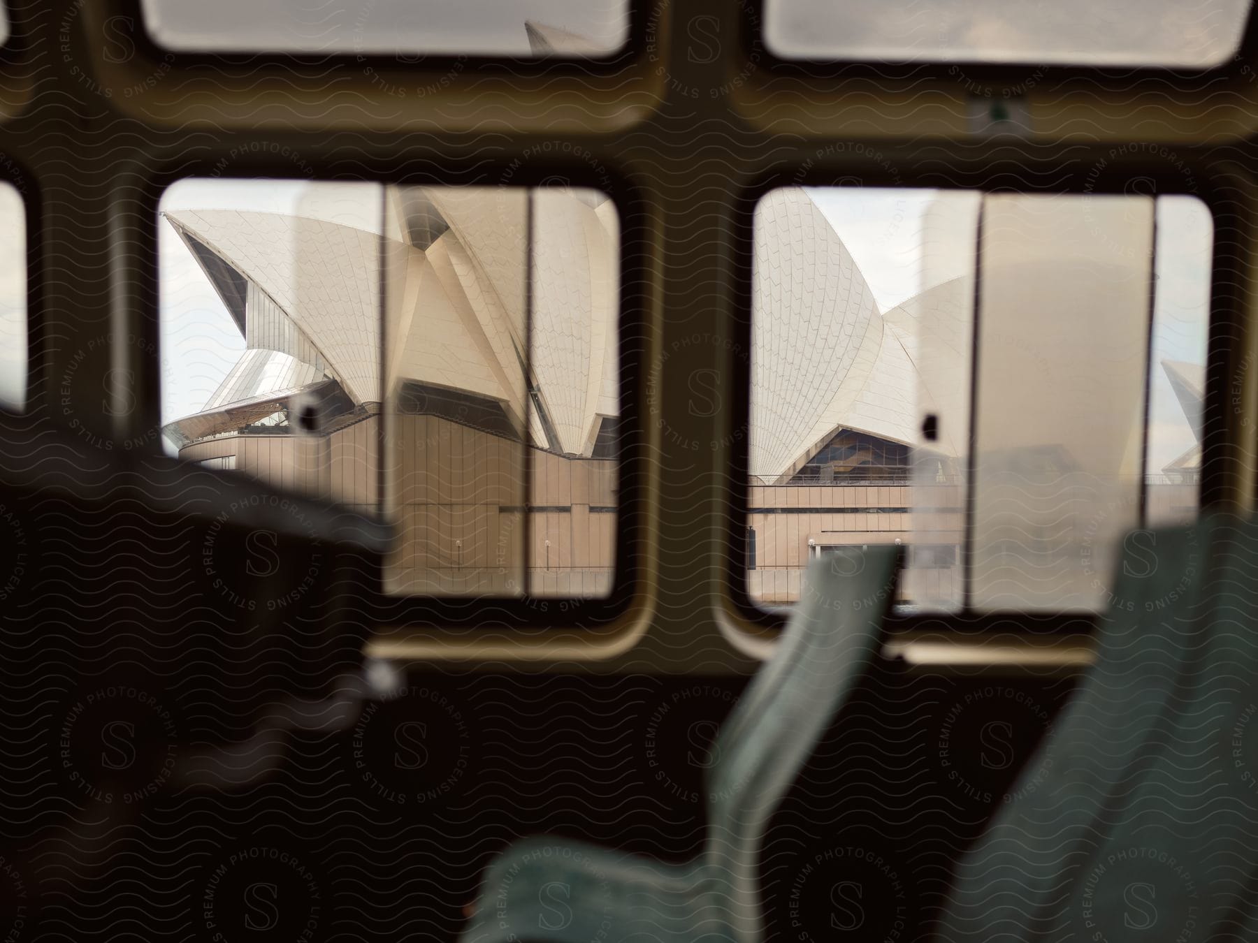 The interior of a vehicle with rectangular windows showing the Sydney Opera House