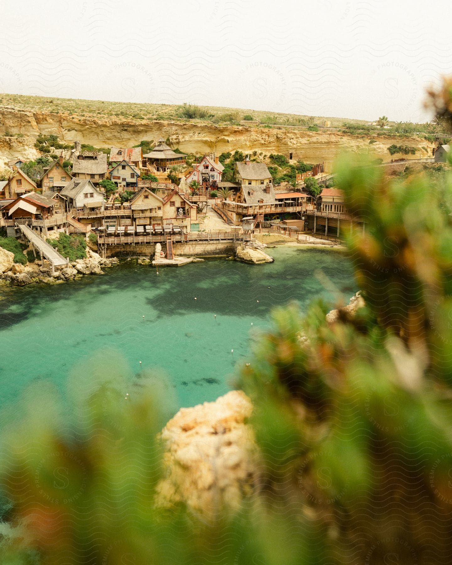 A housing village sits next to a lake on a sunny, summer day.