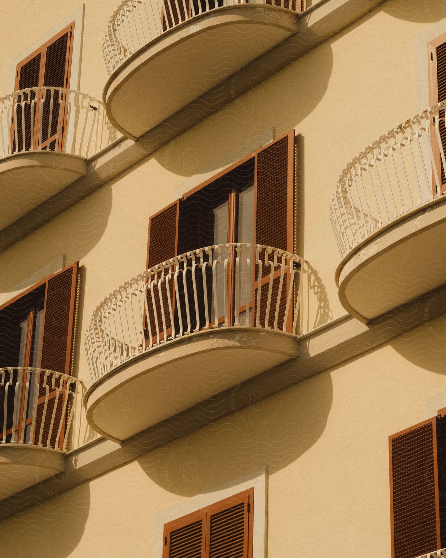 Exterior architecture of an urban building with balconies and wooden shuttered windows