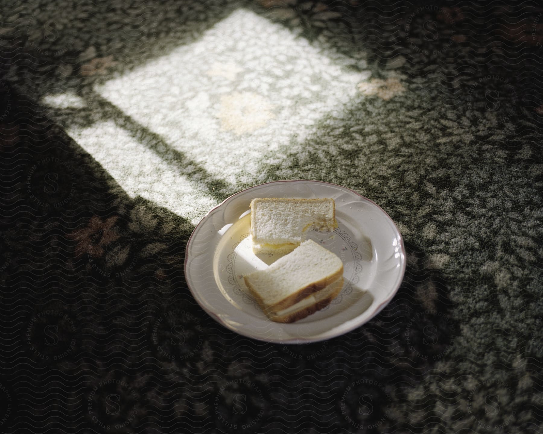 Plate with bread with cheese sliced in half on a rug