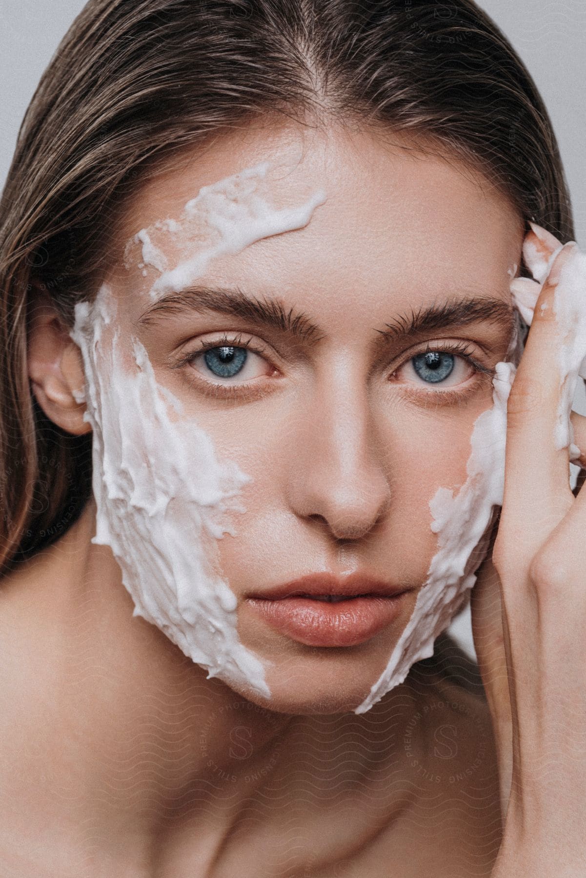 Portrait of a young woman with clear blue eyes with foam on her face