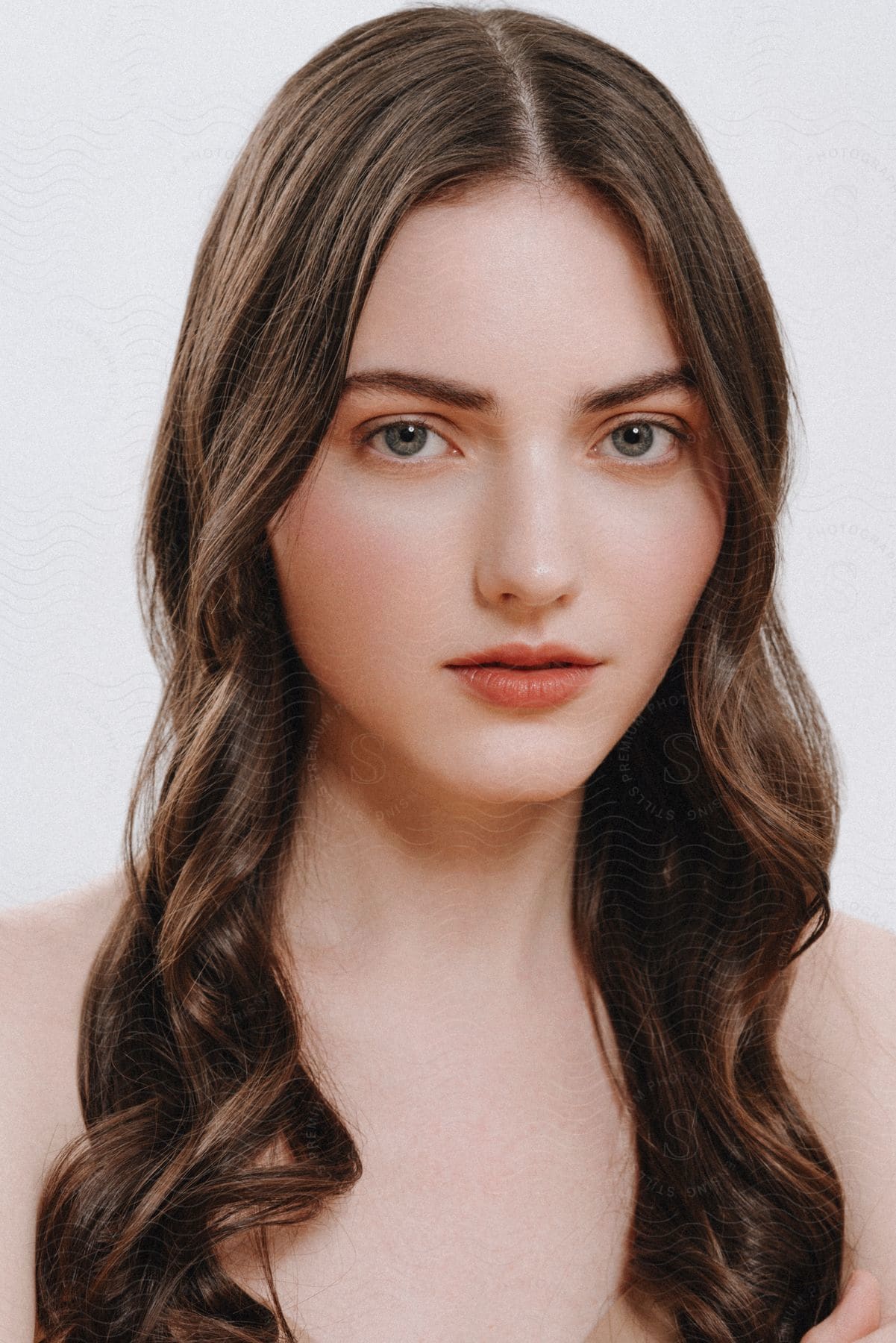 Portrait of a young woman with blue eyes and black hair on a white background