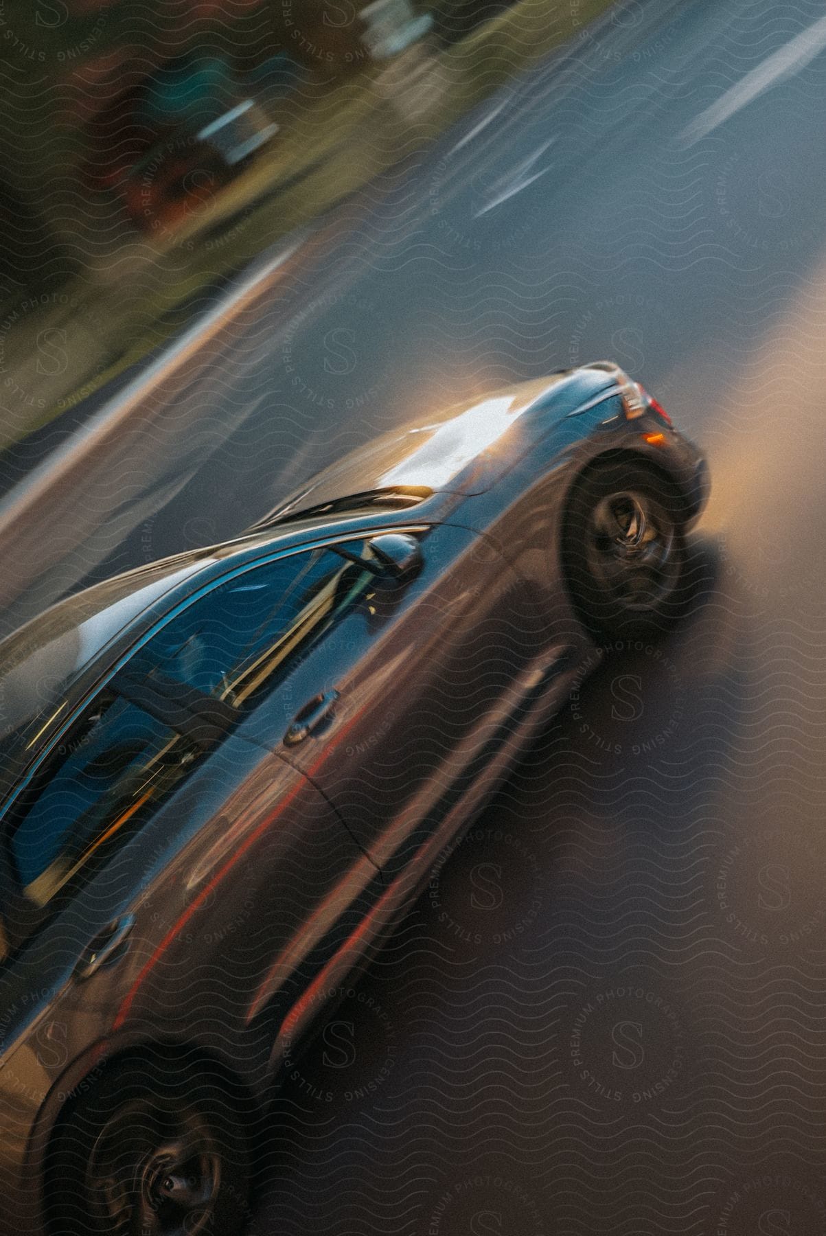 Motion blur effect on a moving car on a street at dusk.