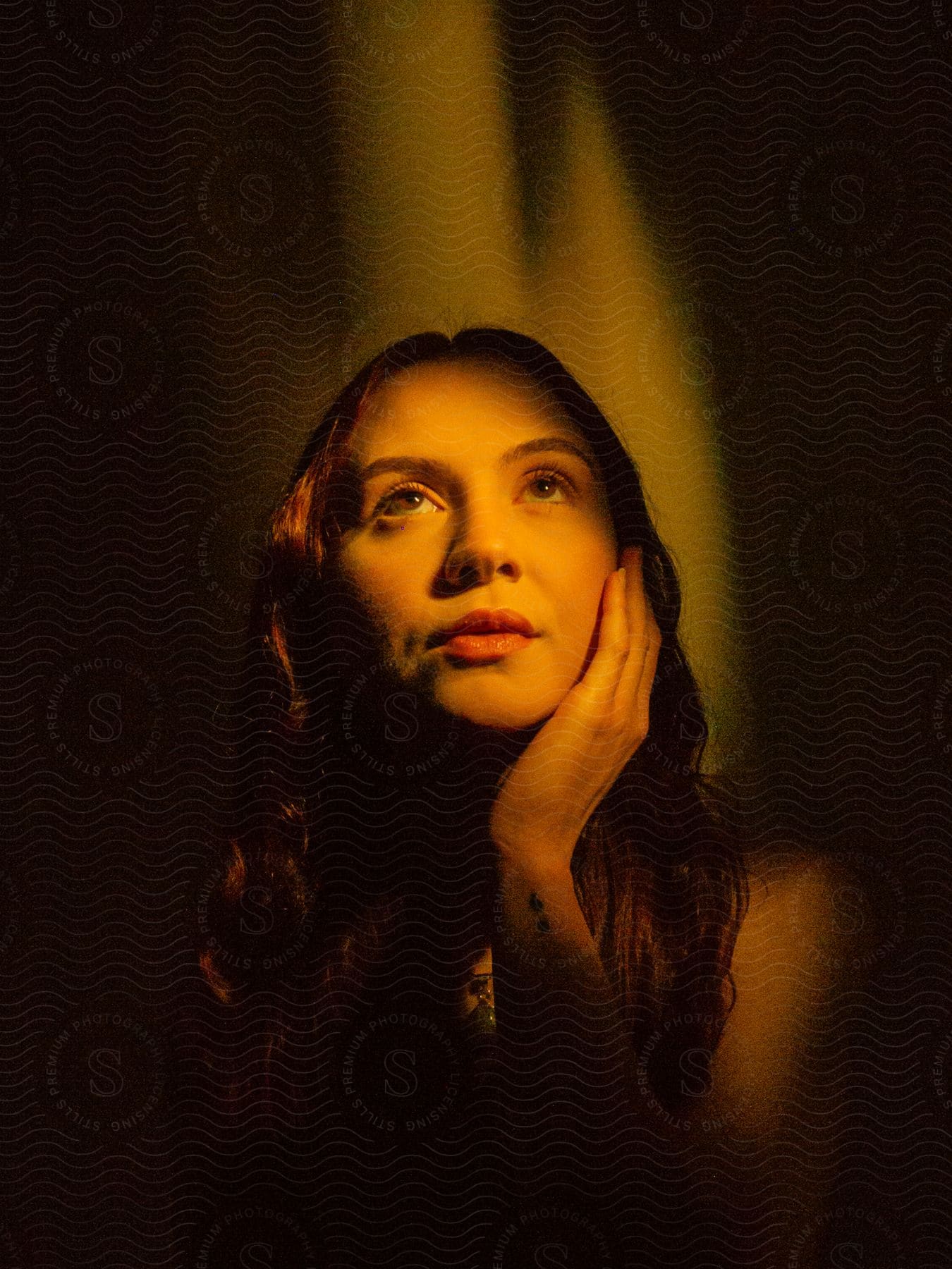 a woman looking up with her hand on her cheek