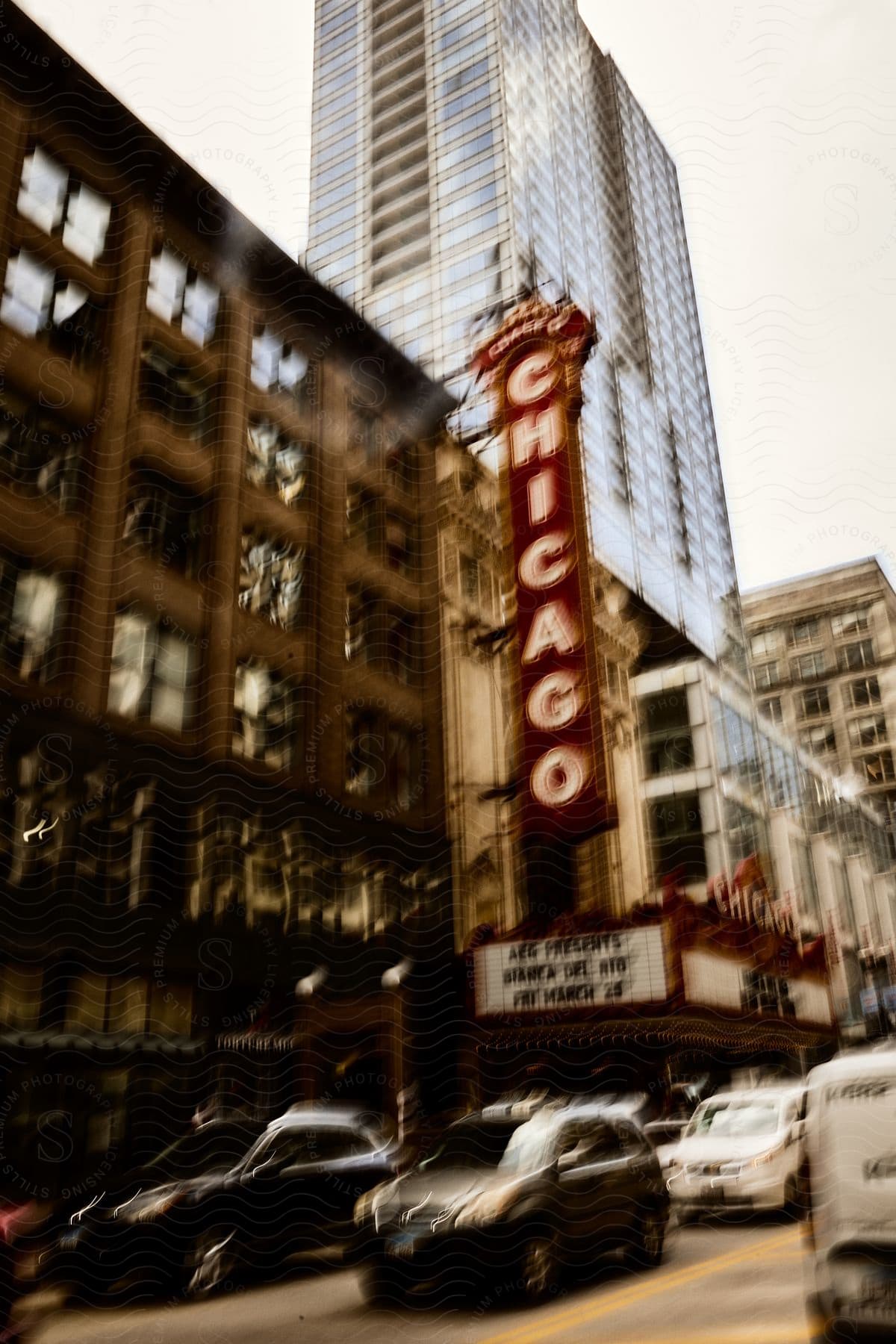 Chicago Theater on a busy street with vehicle traffic and tall buildings.