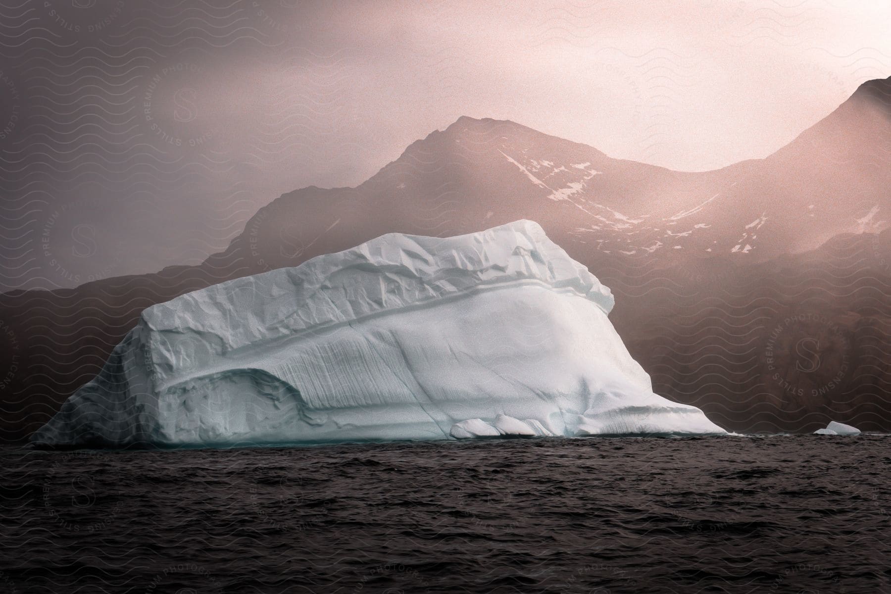 Melting iceberg floats in the water off the coast