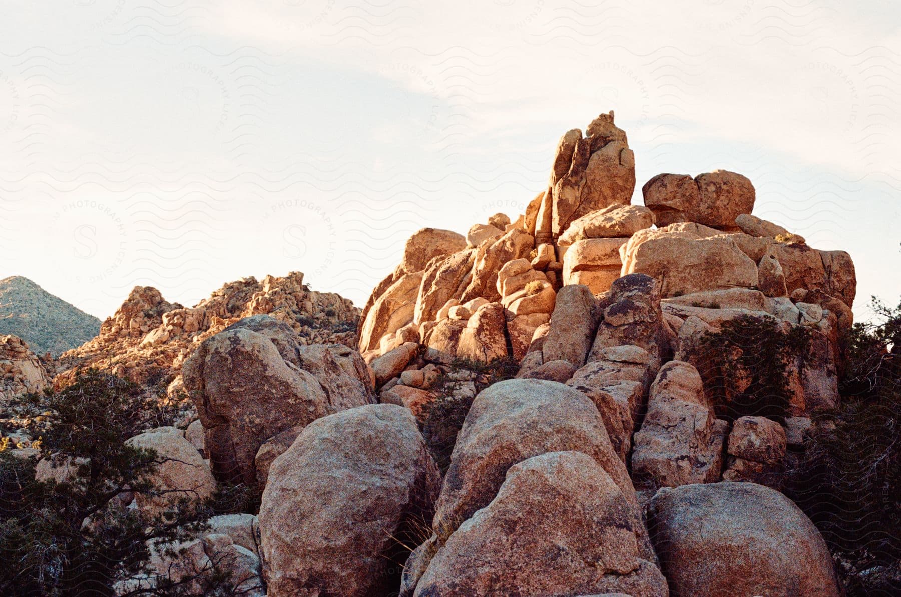 A rocky landscape bathed in warm sunlight with large boulders piled upon each other