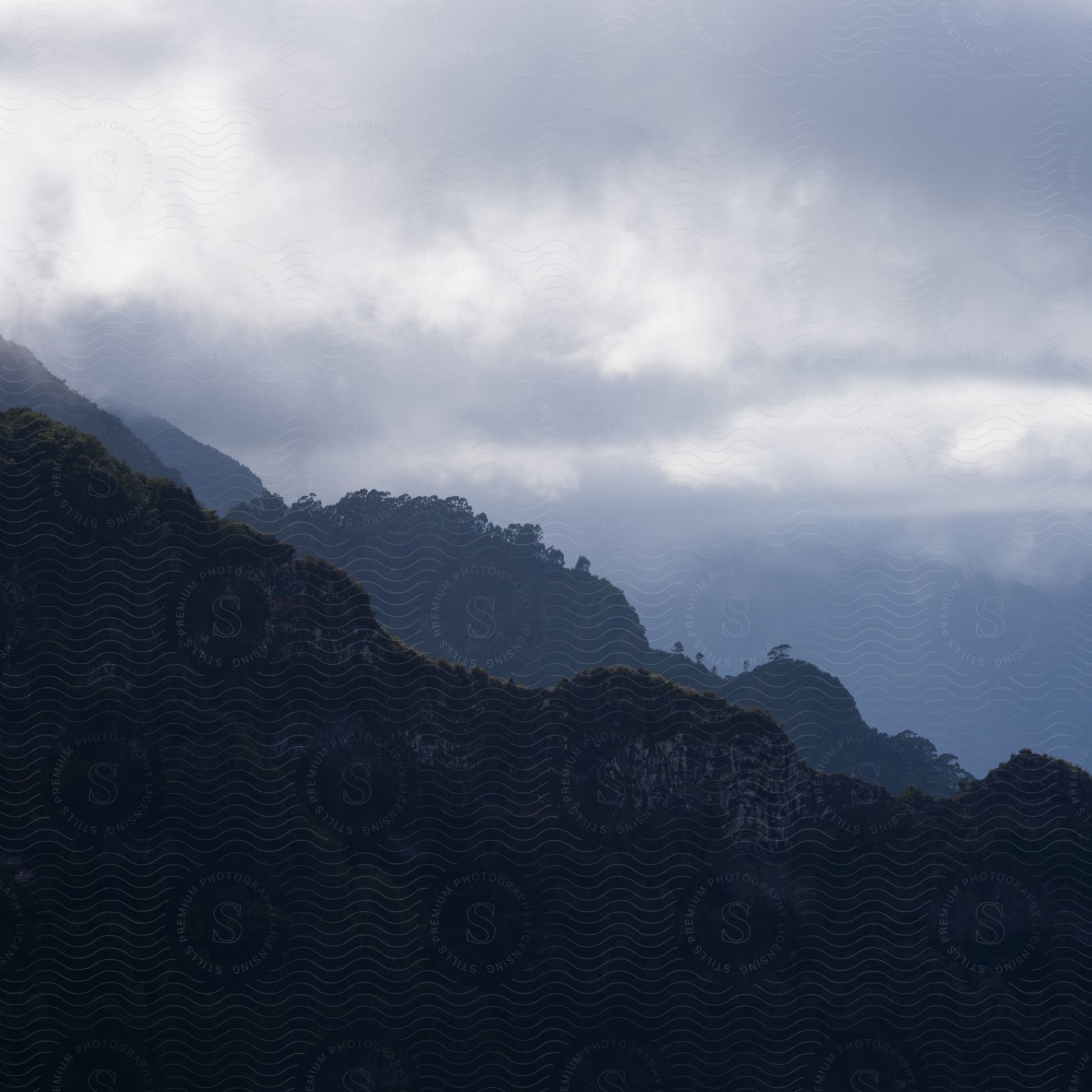 A view of some mountains with clouds in the distance