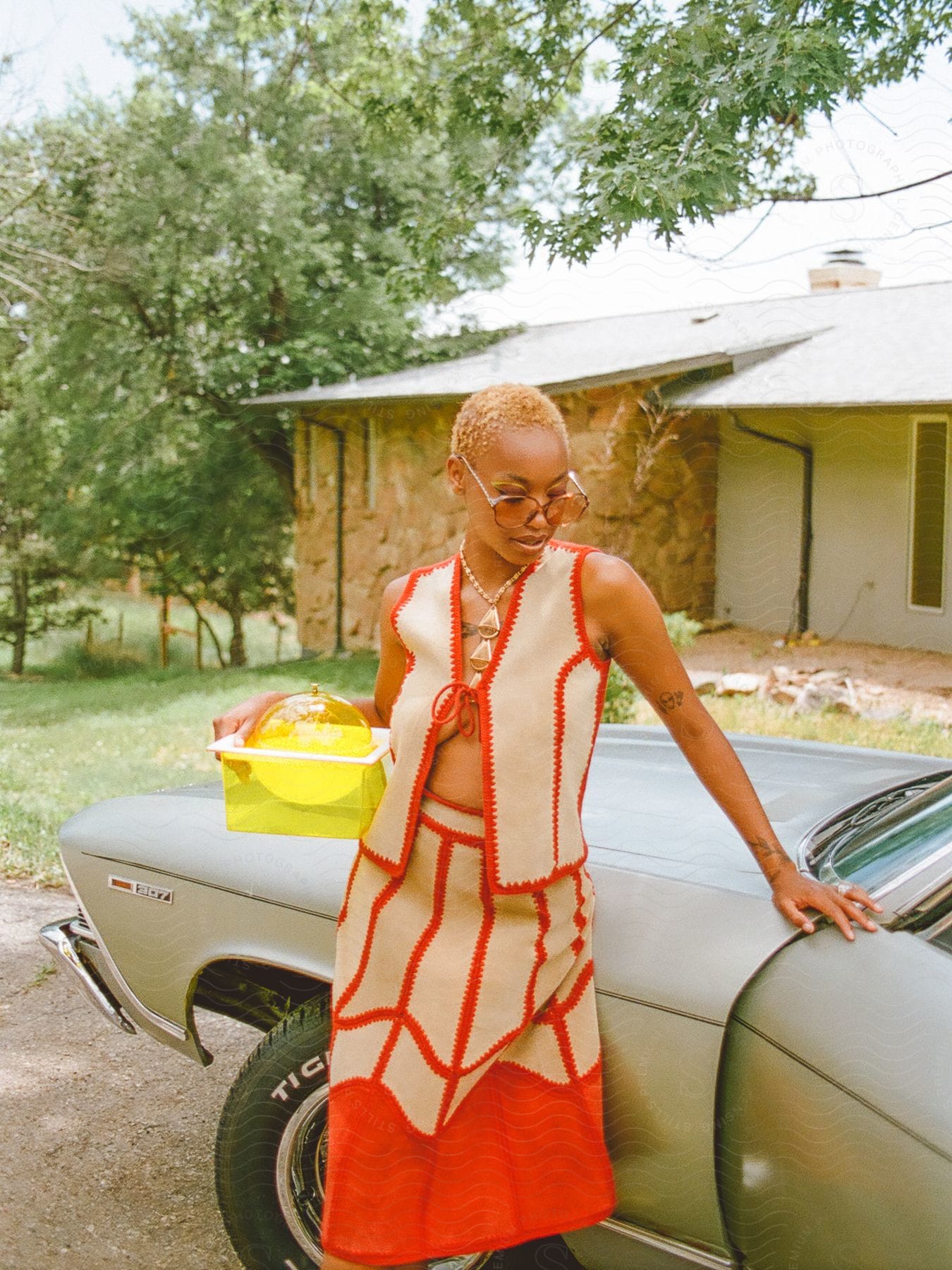 A woman posing next to a car outdoors