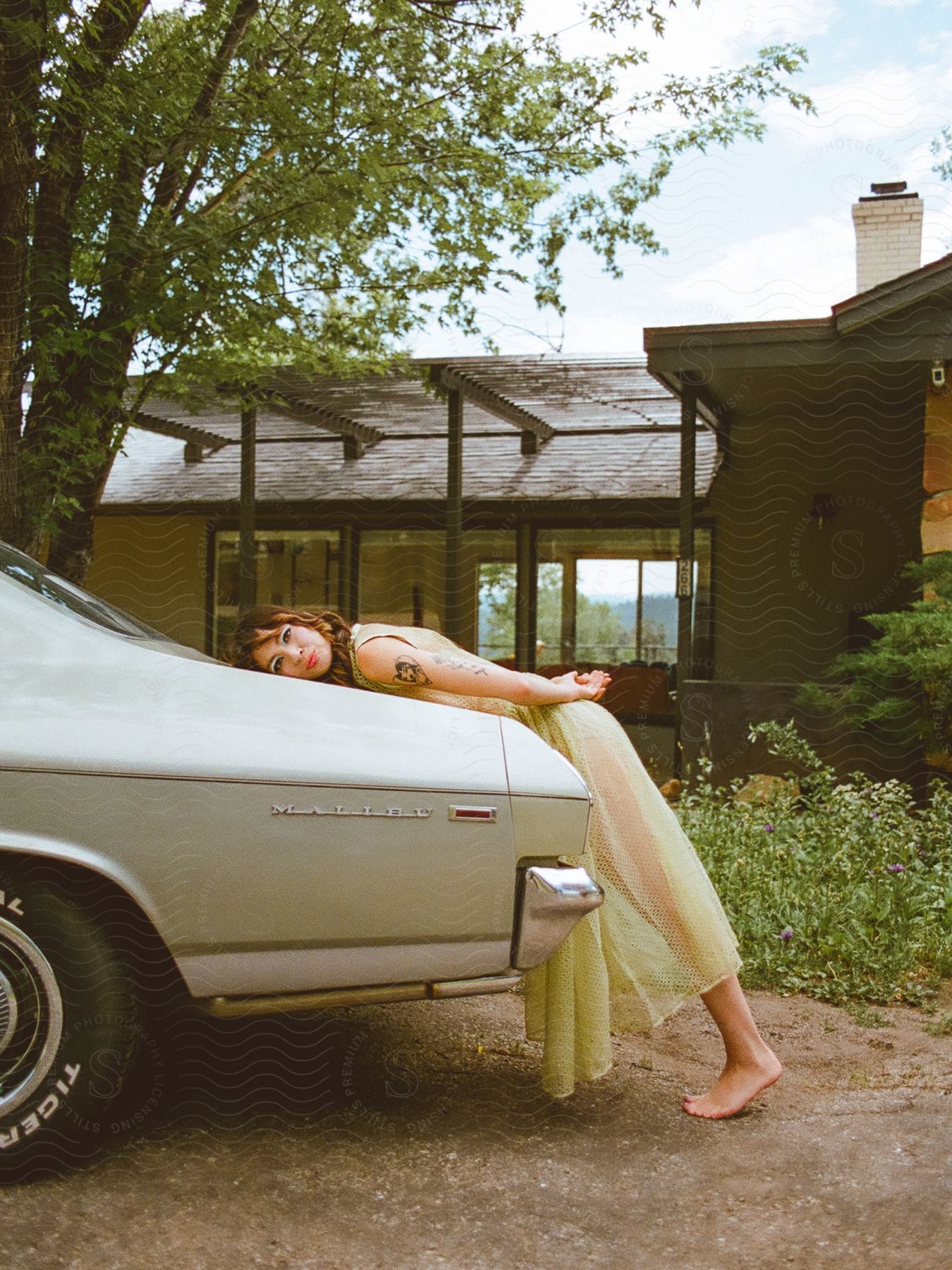 An image of a lady posing on a car