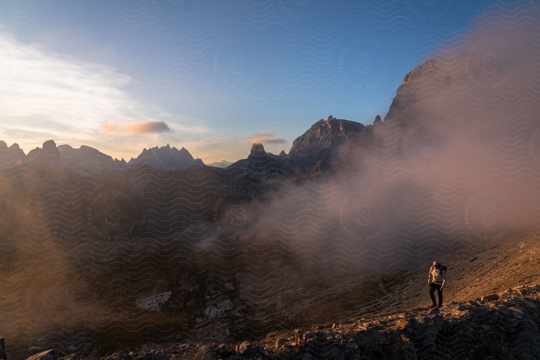 Man hiking in the mountains high in the clouds