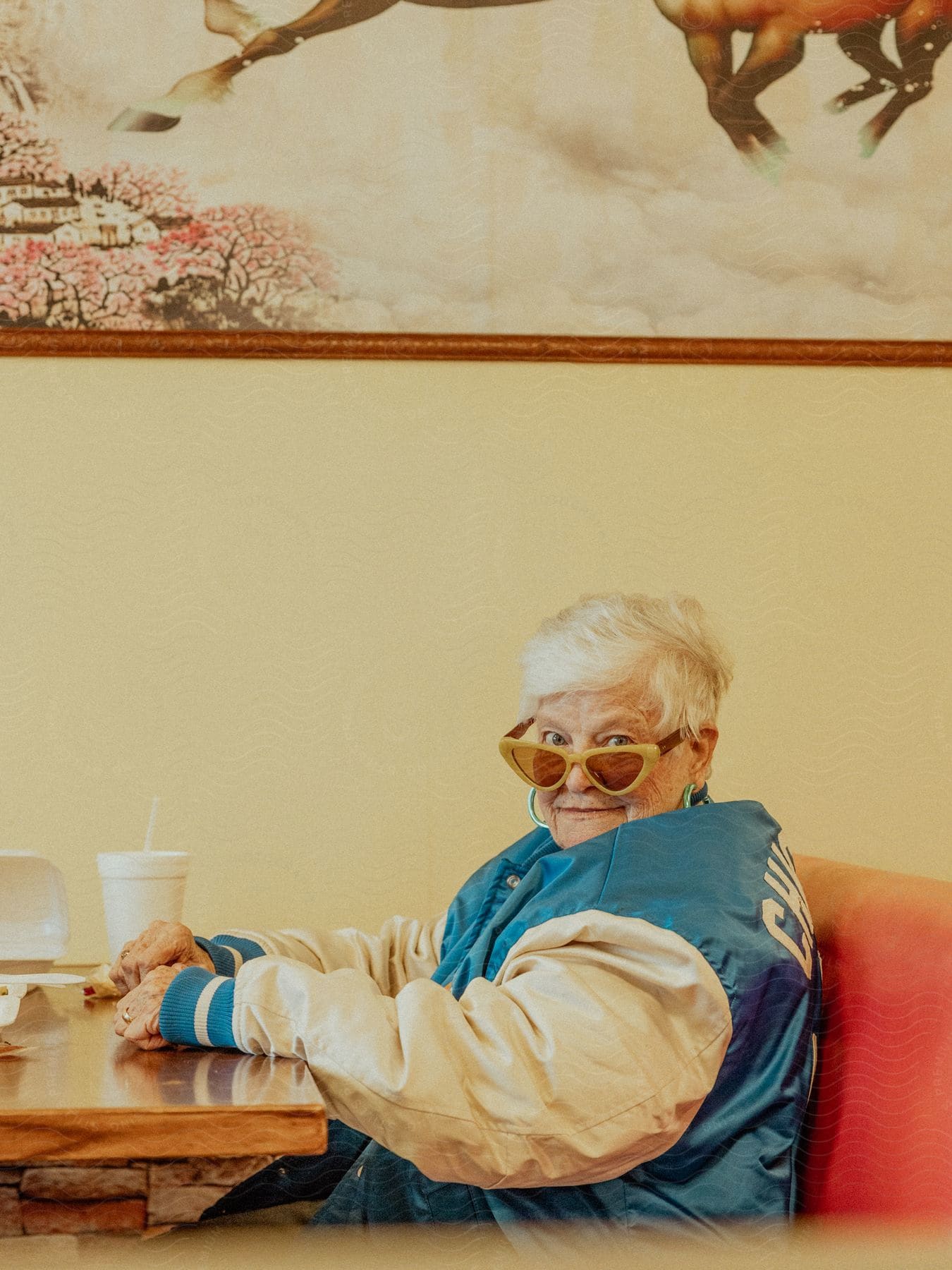 A woman sitting down in a booth at a restaurant