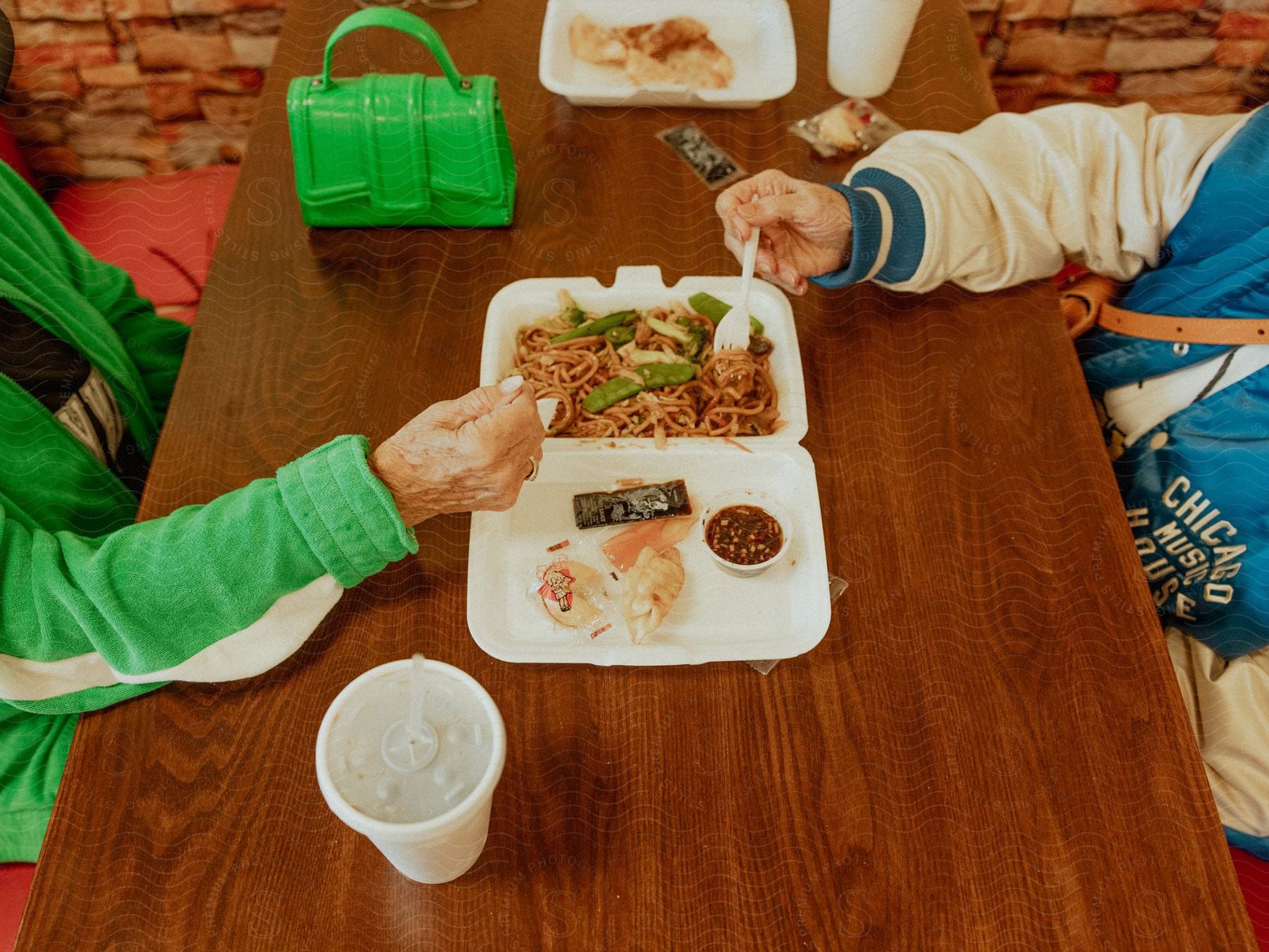 Stock photo of two teenagers sitting at a table sharing spaghetti